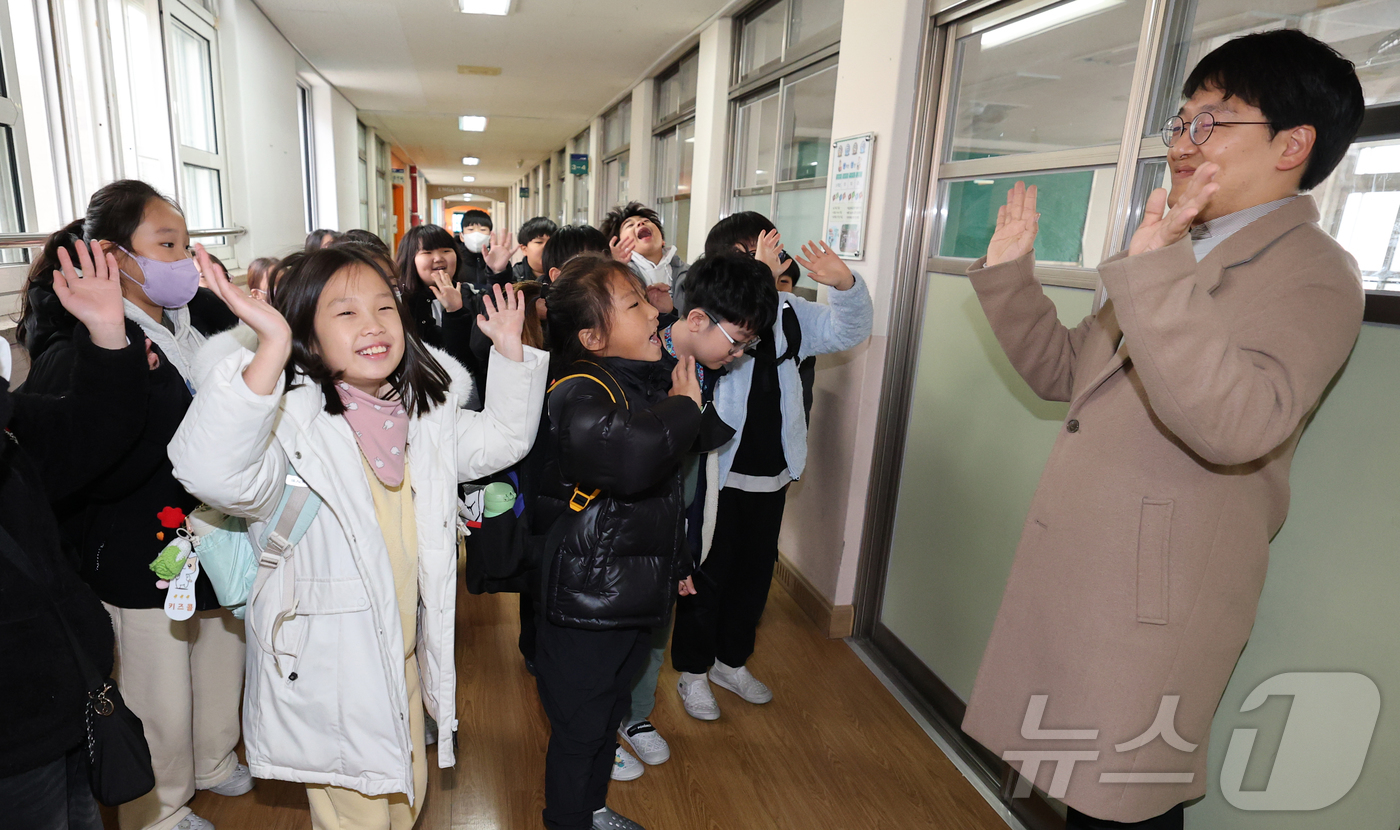 (대전=뉴스1) 김기태 기자 = 대전지역 학교가 순차적으로 방학에 돌입한 가운데 11일 대전 서구 도마초등학교에서 방학을 맞은 3학년 학생들이 하교하며 담임교사와 인사하고 있다.