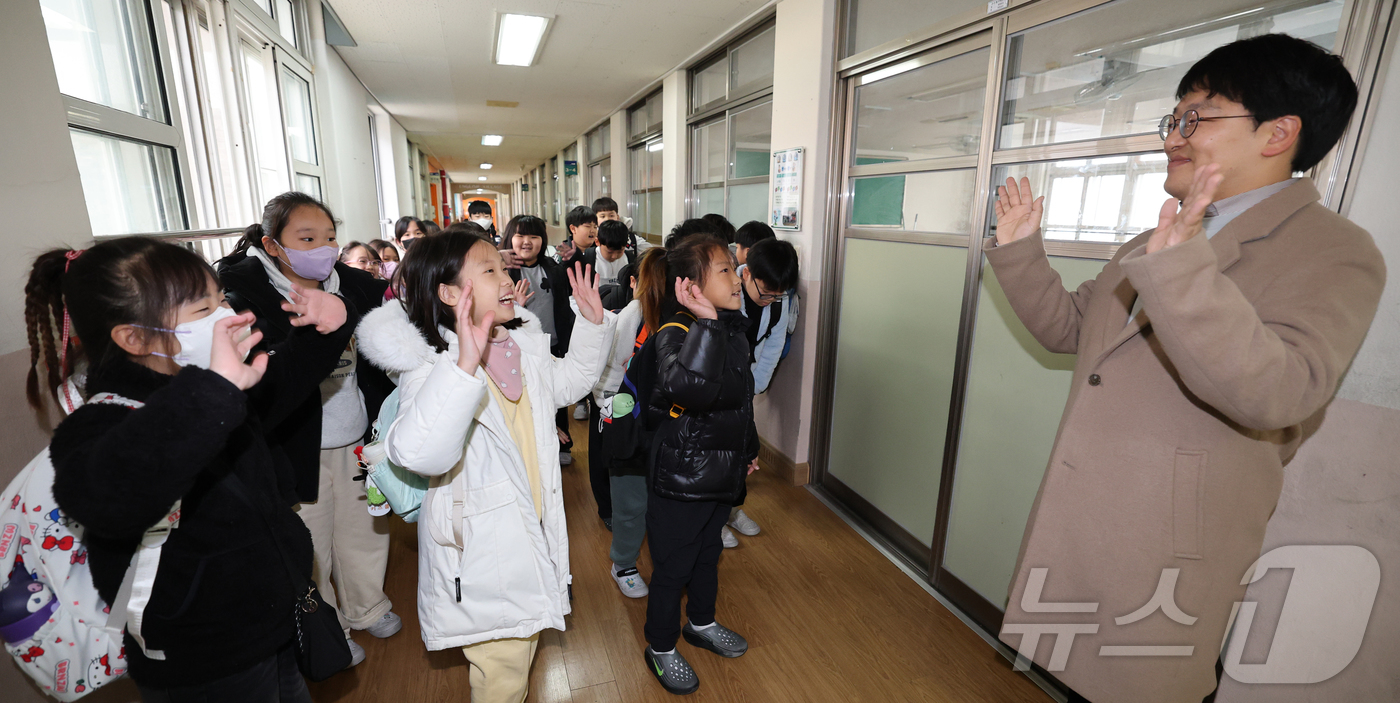 (대전=뉴스1) 김기태 기자 = 대전지역 학교가 순차적으로 방학에 돌입한 가운데 11일 대전 서구 도마초등학교에서 방학을 맞은 3학년 학생들이 하교하며 담임교사와 인사하고 있다.