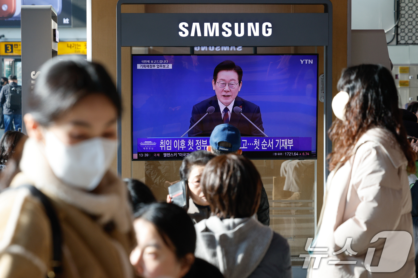 (서울=뉴스1) 안은나 기자 = 11일 서울역에서 이재명 대통령의 취임 후 첫 기관별 업무보고(기획재정부·국가데이터처) 모두 발언 생중계 화면이 나오고 있다.강유정 대통령실 대변인 …