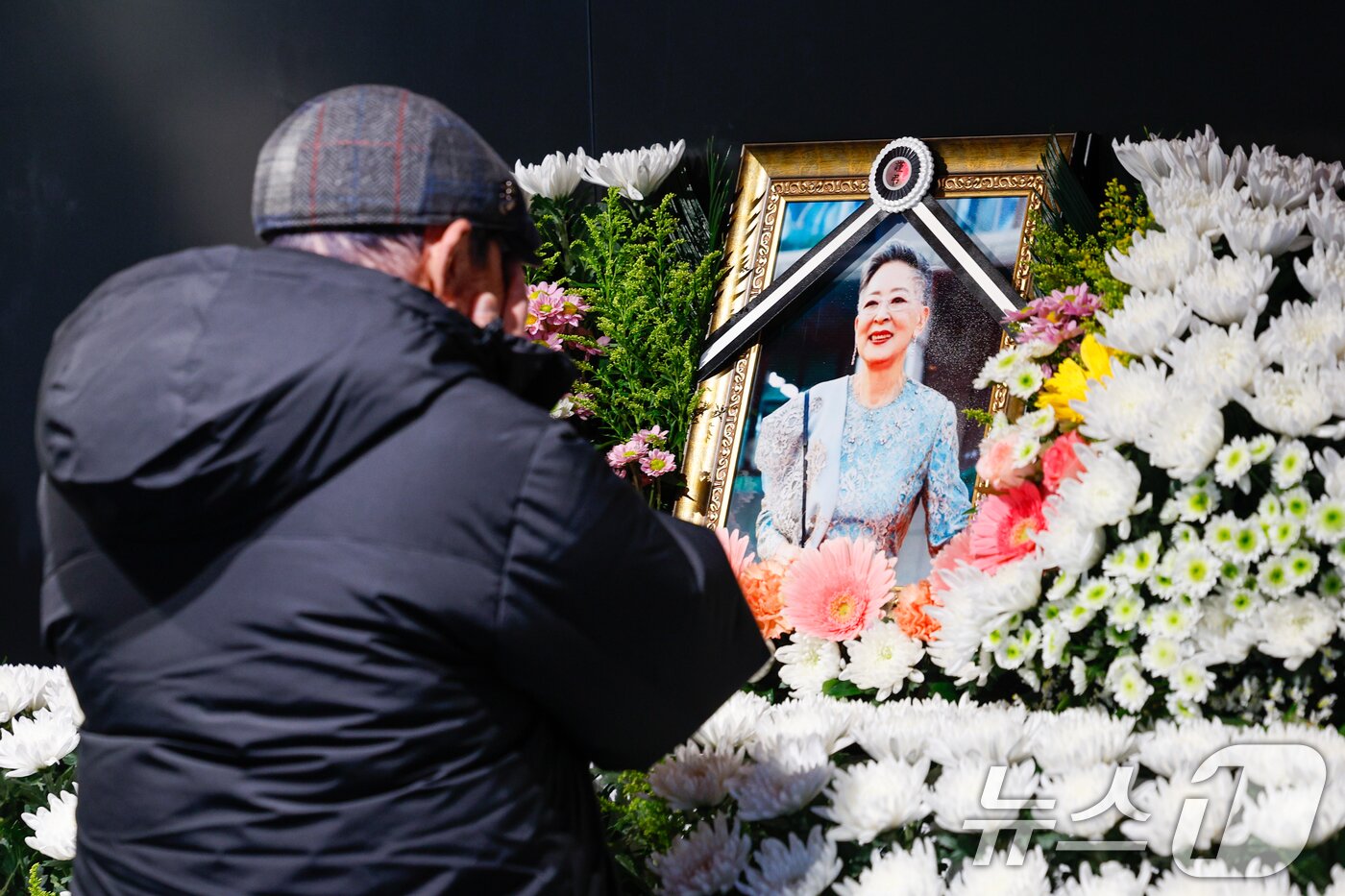 본문 이미지 - 11일 오후 서울 중구 충무로 서울영화센터에 마련된 원로 배우 고&#40;故&#41; 김지미&#40;본명 김명자&#41;의 추모 공간을 찾은 시민이 슬픔에 잠겨 있다. 2025.12.11/뉴스1 ⓒ News1 안은나 기자