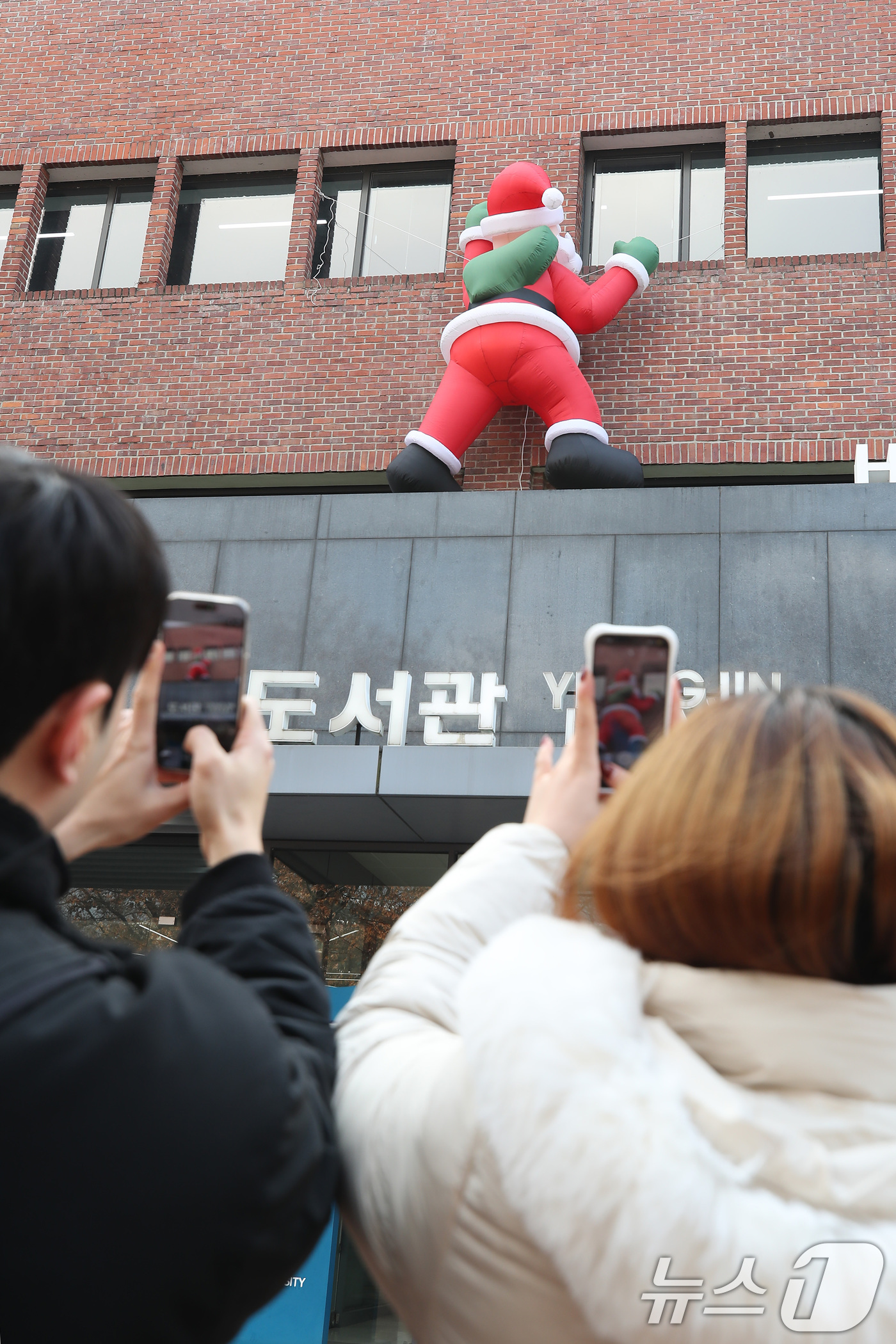 (대구=뉴스1) 공정식 기자 = 11일 오후 크리스마스를 앞두고 대구 북구 영진전문대 도서관 외벽에 설치된 산타 인형이 기말고사를 맞아 도서관을 찾는 학생들의 눈길을 끌고 있다. …