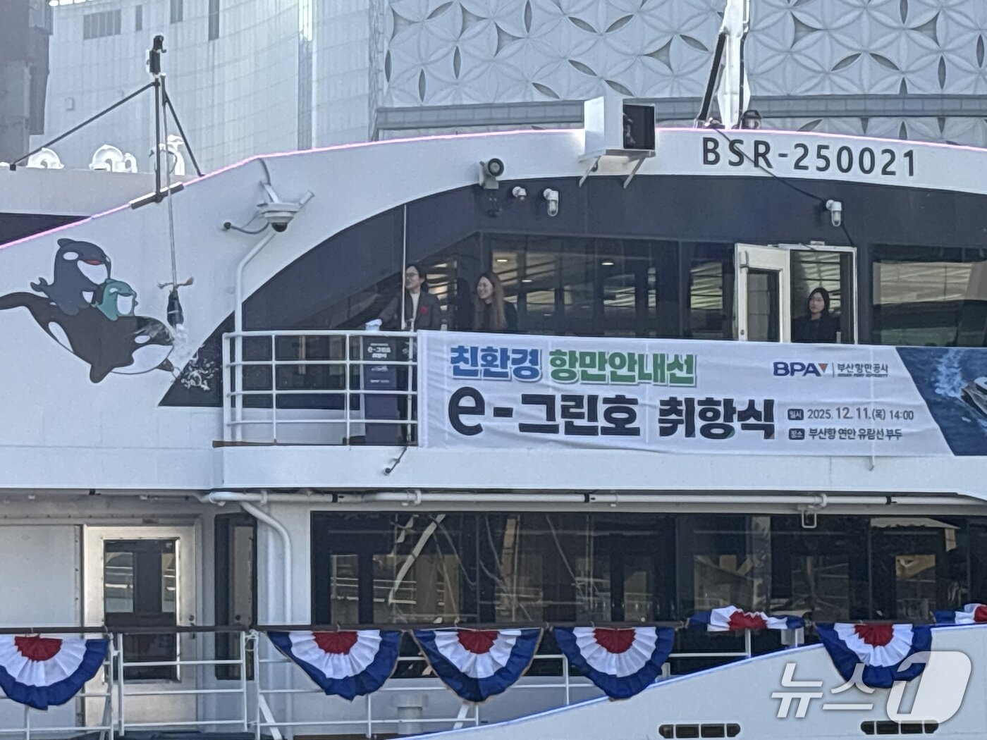 본문 이미지 - e-그린호에 샴페인브레이킹 세리머니를 하는 모습. 생명 탄생의 축복을 기원하는 의식으로 관례적으로 '대모' 역할을 맡은 여성이 세리머니를 한다. 2025.12.11. ⓒ 뉴스1 홍윤 기자