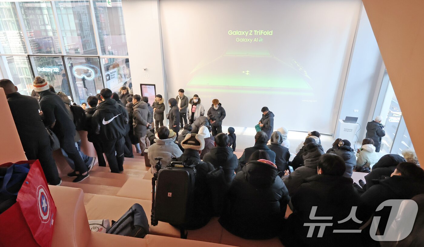 본문 이미지 - 갤럭시 Z 트라이폴드가 출시된 12일 오전 서울 서초구 삼성 강남을 찾은 방문객들이 제품을 구매하기 위해 대기하고 있다. 2025.12.12/뉴스1 ⓒ News1 장수영 기자