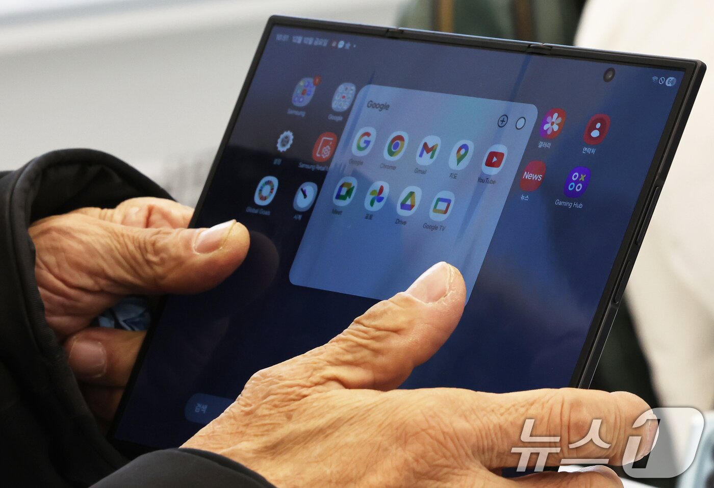 본문 이미지 - 갤럭시 Z 트라이폴드가 출시된 12일 오전 서울 서초구 삼성 강남을 찾은 어르신이 제품을 살펴보고 있다. 2025.12.12/뉴스1 ⓒ News1 장수영 기자