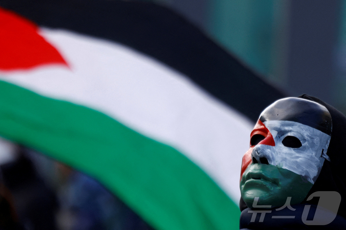 (더블린 로이터=뉴스1) 강민경 기자 = 지난 11월 2일 아일랜드 더블린에서 한 친팔레스타인 시위자가 얼굴에 팔레스타인 깃발 색을 칠한 채 팔레스타인 국기 앞에 서 있다. 202 …