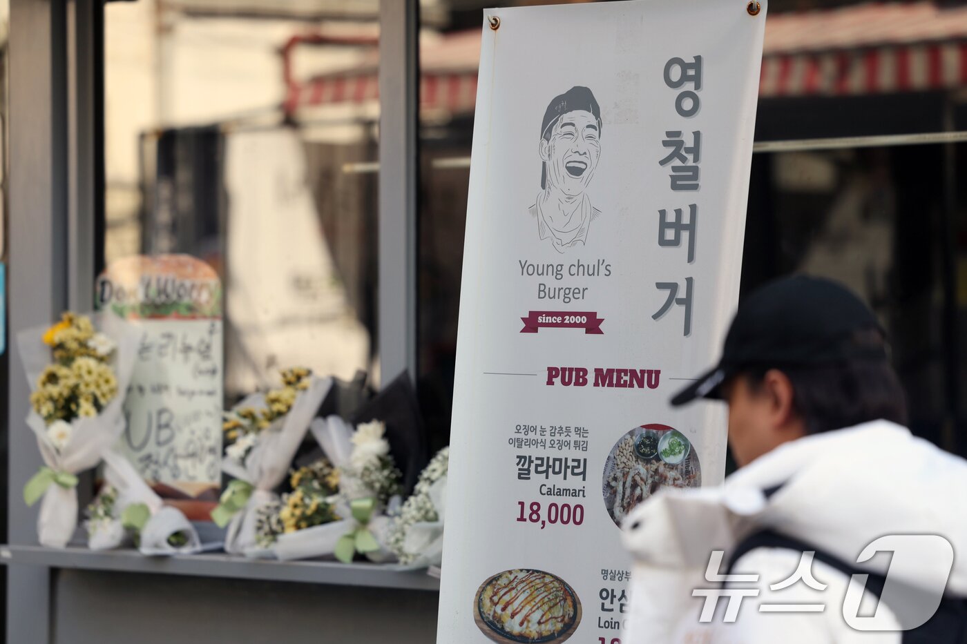 본문 이미지 - 14일 오전 서울 성북구 안암동 영철버거 앞에 영철버거 대표 이영철 씨의 별세 소식을 추모하는 꽃이 놓여져 있다.   2025.12.14/뉴스1 ⓒ News1 황기선 기자