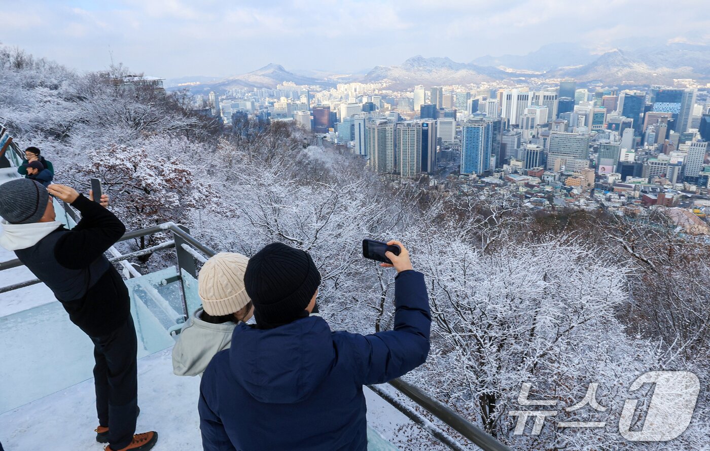 본문 이미지 - 지난 밤 내린 눈이 쌓인 14일 서울 용산구 남산공원을 찾은 시민들이 겨울풍경을 만끽하고 있다. 2025.12.14/뉴스1 ⓒ News1 이호윤 기자