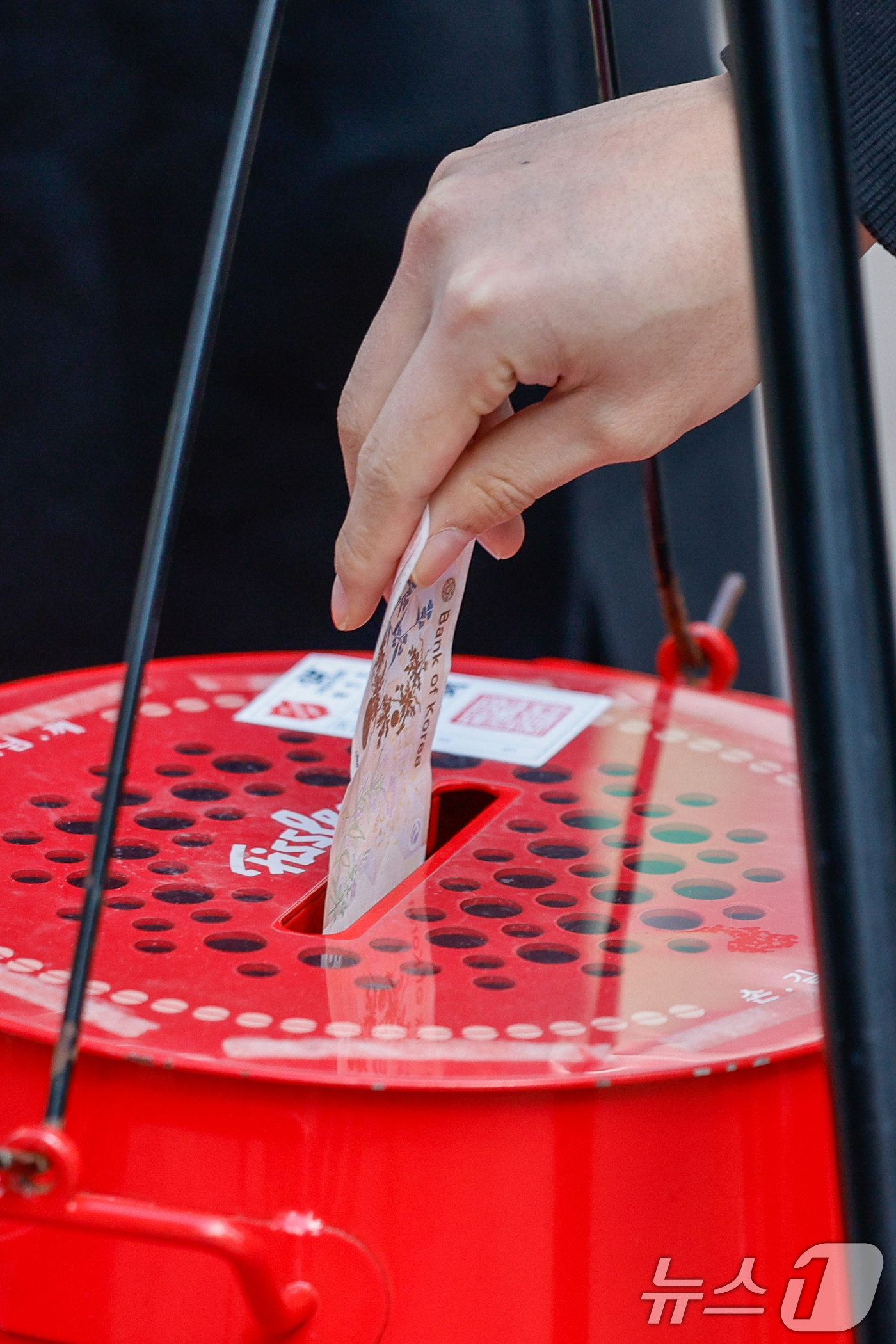 (서울=뉴스1) 안은나 기자 = 14일 서울 중구 명동거리에서 한 시민이 구세군 연말 거리모금 캠페인 자선냄비에 온정의 손길을 더하고 있다. 2025.12.14/뉴스1