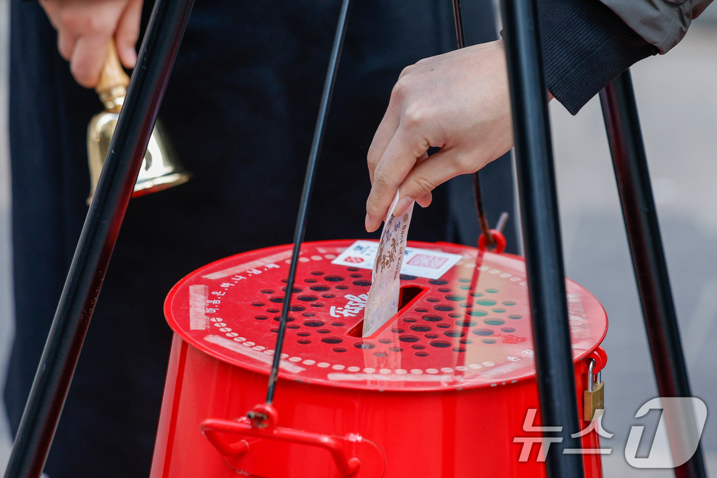 (서울=뉴스1) 안은나 기자 = 14일 서울 중구 명동거리에서 한 시민이 구세군 연말 거리모금 캠페인 자선냄비에 온정의 손길을 더하고 있다. 2025.12.14/뉴스1