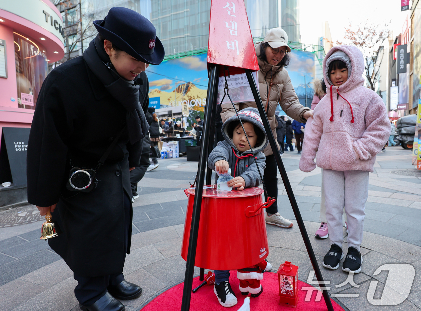 (서울=뉴스1) 안은나 기자 = 14일 서울 중구 명동거리에서 한 어린이가 구세군 연말 거리모금 캠페인 자선냄비에 온정의 손길을 더하고 있다. 2025.12.14/뉴스1