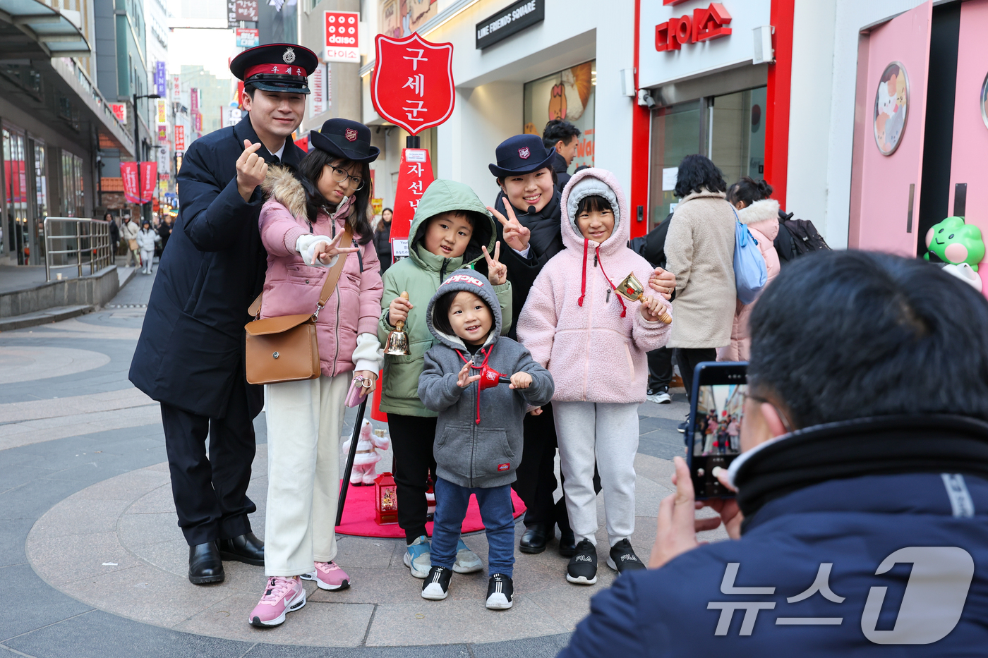 (서울=뉴스1) 안은나 기자 = 14일 서울 중구 명동거리에서 구세군 연말 거리모금 캠페인 자선냄비에 온정의 손길을 더한 어린이들이 기념 촬영을 하고 있다. 2025.12.14/뉴 …