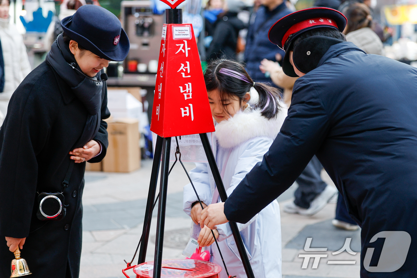 (서울=뉴스1) 안은나 기자 = 14일 서울 중구 명동거리에서 한 어린이가 구세군 연말 거리모금 캠페인 자선냄비에 온정의 손길을 더하고 있다. 2025.12.14/뉴스1
