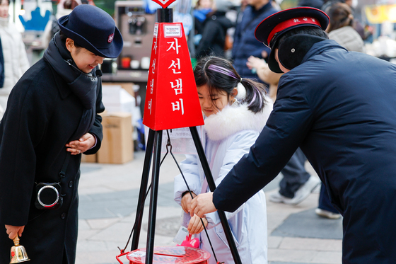 자선냄비에 성금 넣는 어린이