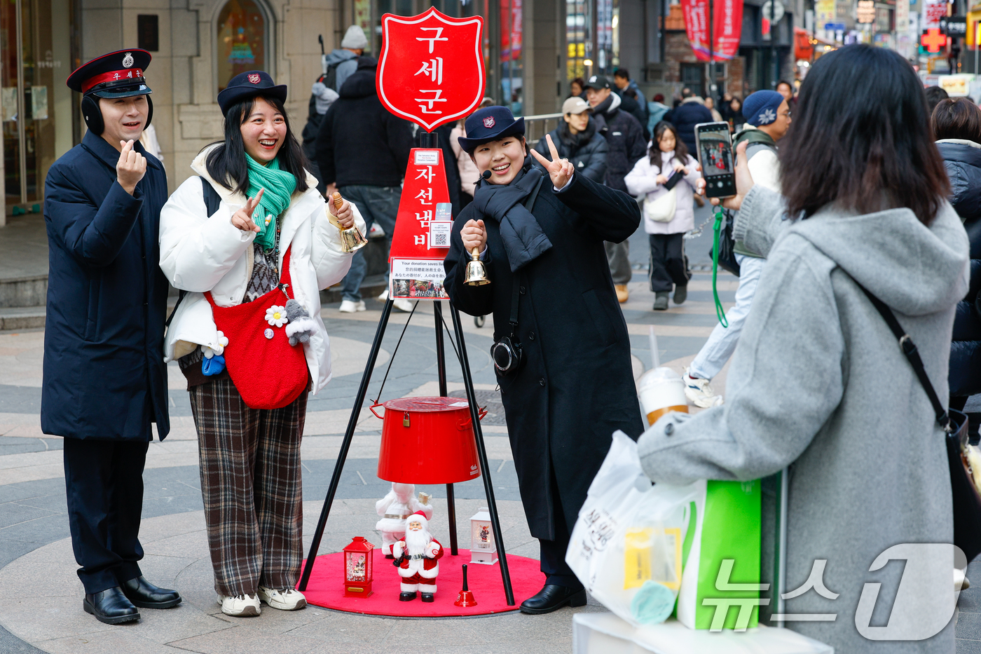 (서울=뉴스1) 안은나 기자 = 14일 서울 중구 명동거리에서 외국인 관광객이 구세군 연말 거리모금 캠페인 자선냄비를 찾아 기념 촬영을 하고 있다. 2025.12.14/뉴스1