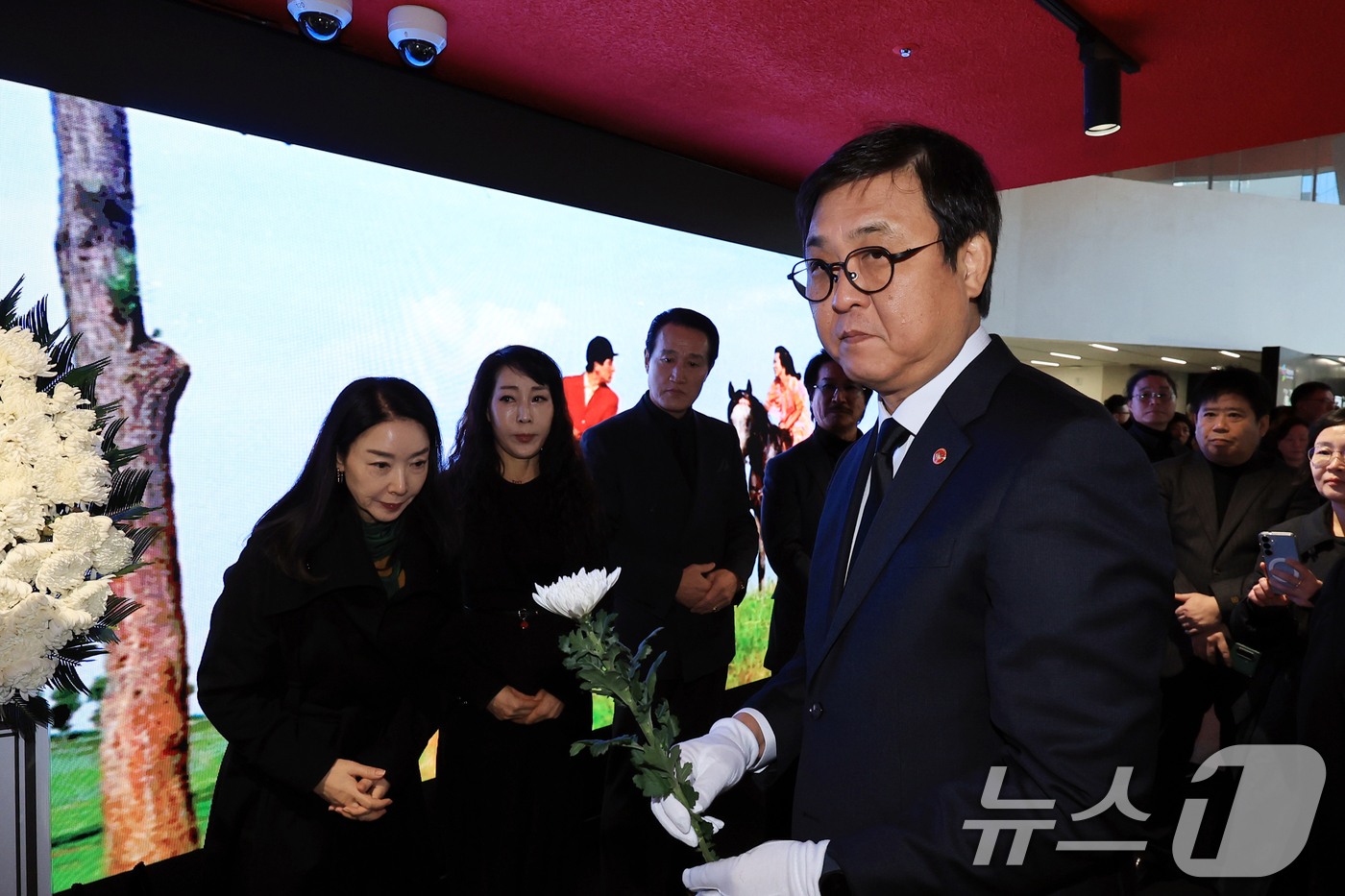 (서울=뉴스1) 이호윤 기자 = 최휘영 문화체육관광부 장관이 14일 서울 중구 서울영화센터에 마련된 고 김지미 배우의 추모공간을 찾아 헌화를 하고 있다. 2025.12.14/뉴스1 …