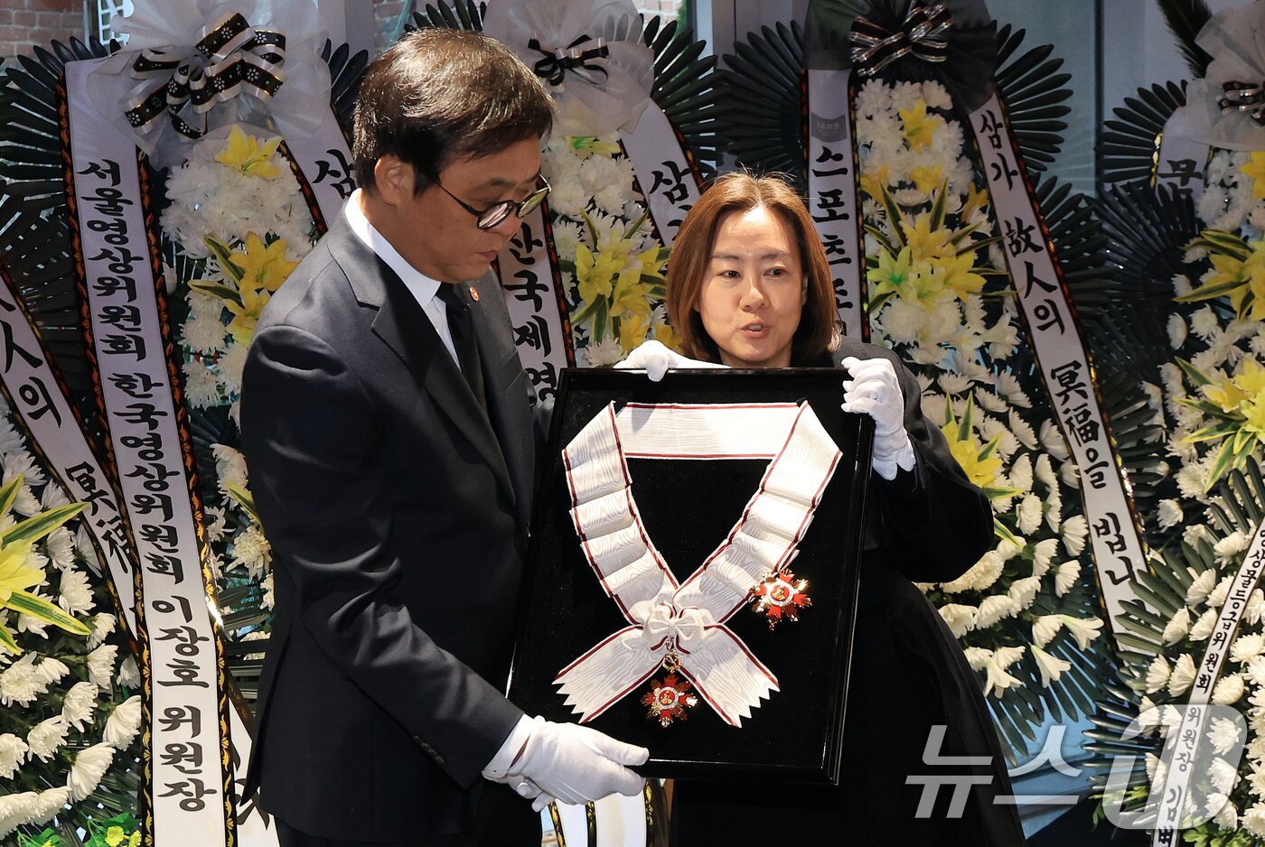 본문 이미지 - 최휘영 문화체육관광부 장관이 14일 서울 중구 서울영화센터에 마련된 고 김지미 배우의 추모공간을 찾아 금관문화훈장을 전달하고 있다. 2025.12.14/뉴스1 ⓒ News1 이호윤 기자