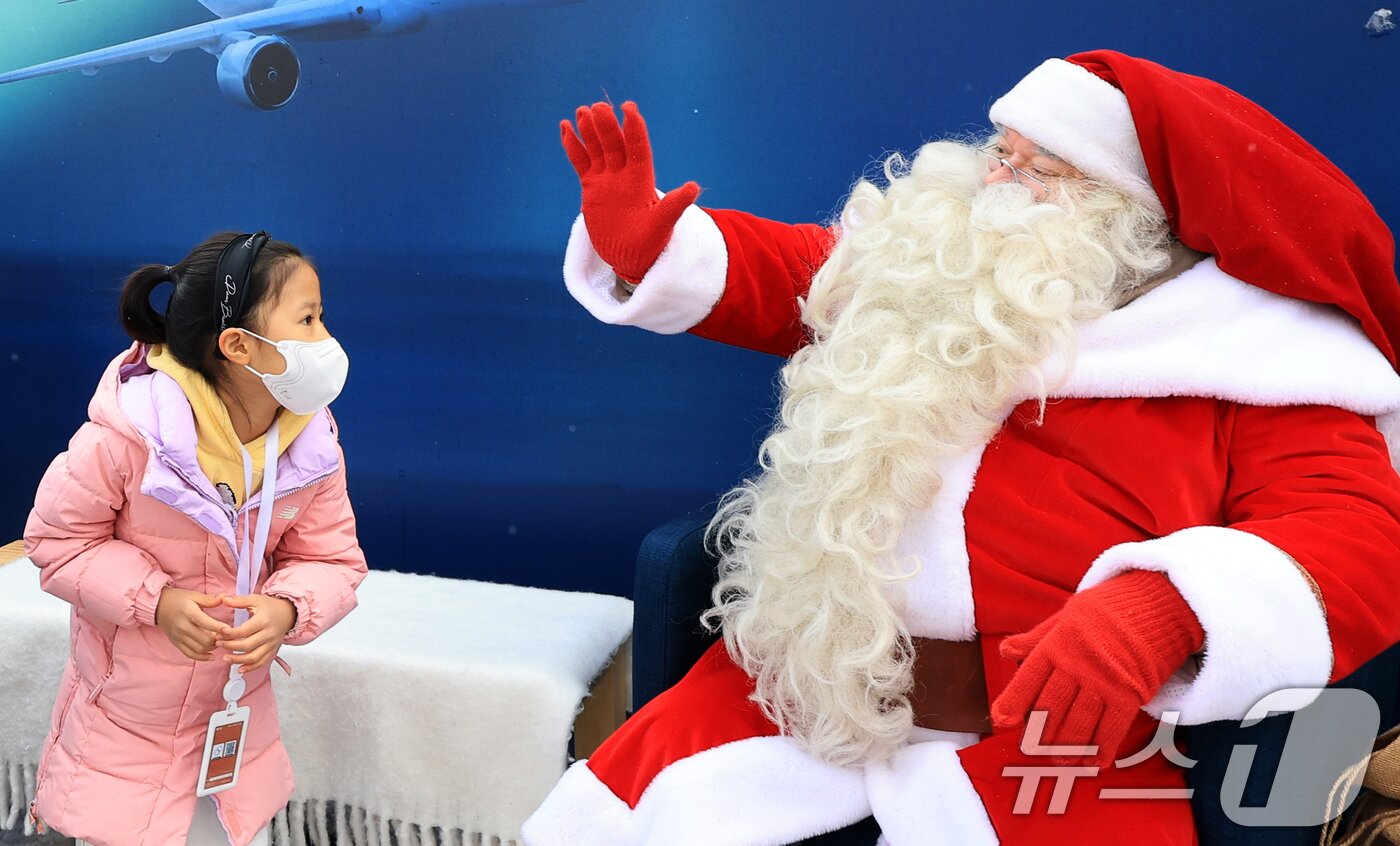 본문 이미지 - 한국을 찾은 핀란드 공인 산타클로스가 14일 서울 중구 남산타워 앞에서 아이와 인사를 나누고 있다. 2025.12.14/뉴스1 ⓒ News1 이호윤 기자