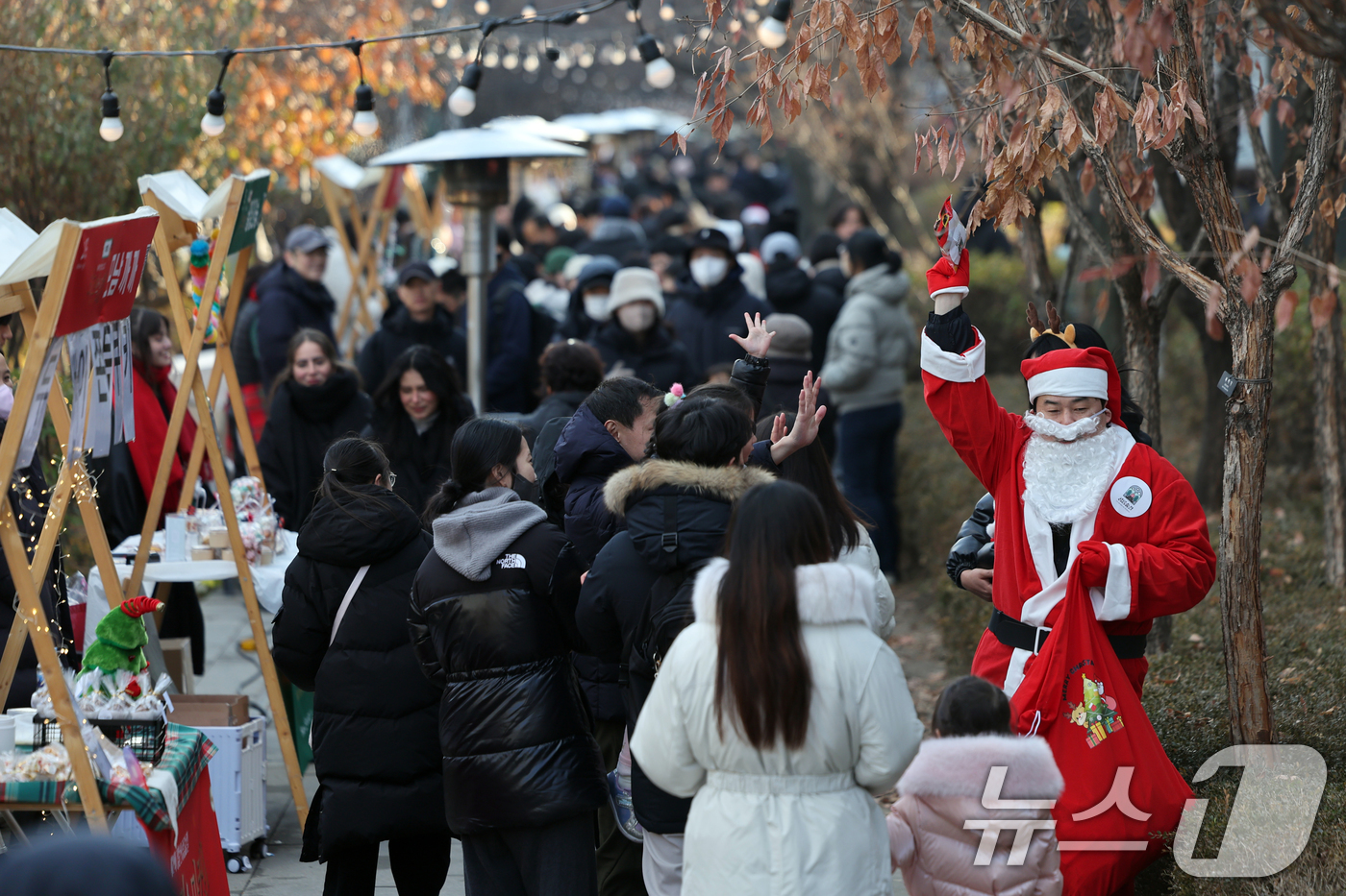 (서울=뉴스1) 황기선 기자 = 14일 오후 서울 노원구 경춘선 공릉숲길에서 열린 '2025 제2회 노원 크리스마스 마켓'에서 산타 복장을 한 행사 관계자가 시민들에게 인사를 하고 …