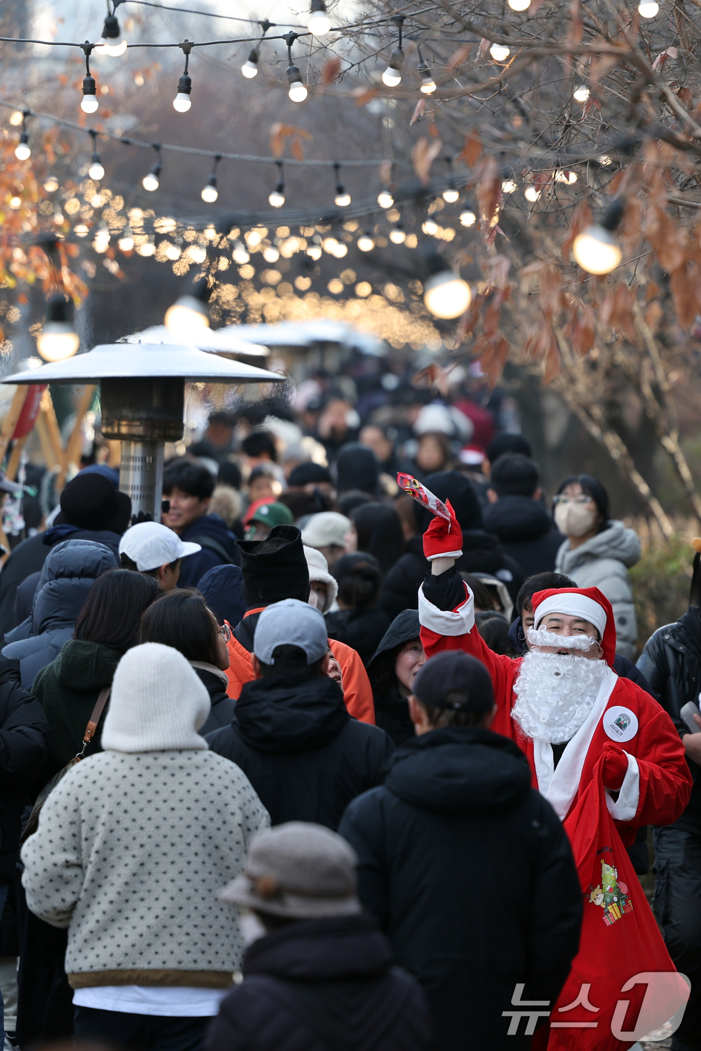 (서울=뉴스1) 황기선 기자 = 14일 오후 서울 노원구 경춘선 공릉숲길에서 열린 '2025 제2회 노원 크리스마스 마켓'에서 산타 복장을 한 행사 관계자가 시민들에게 인사를 하고 …