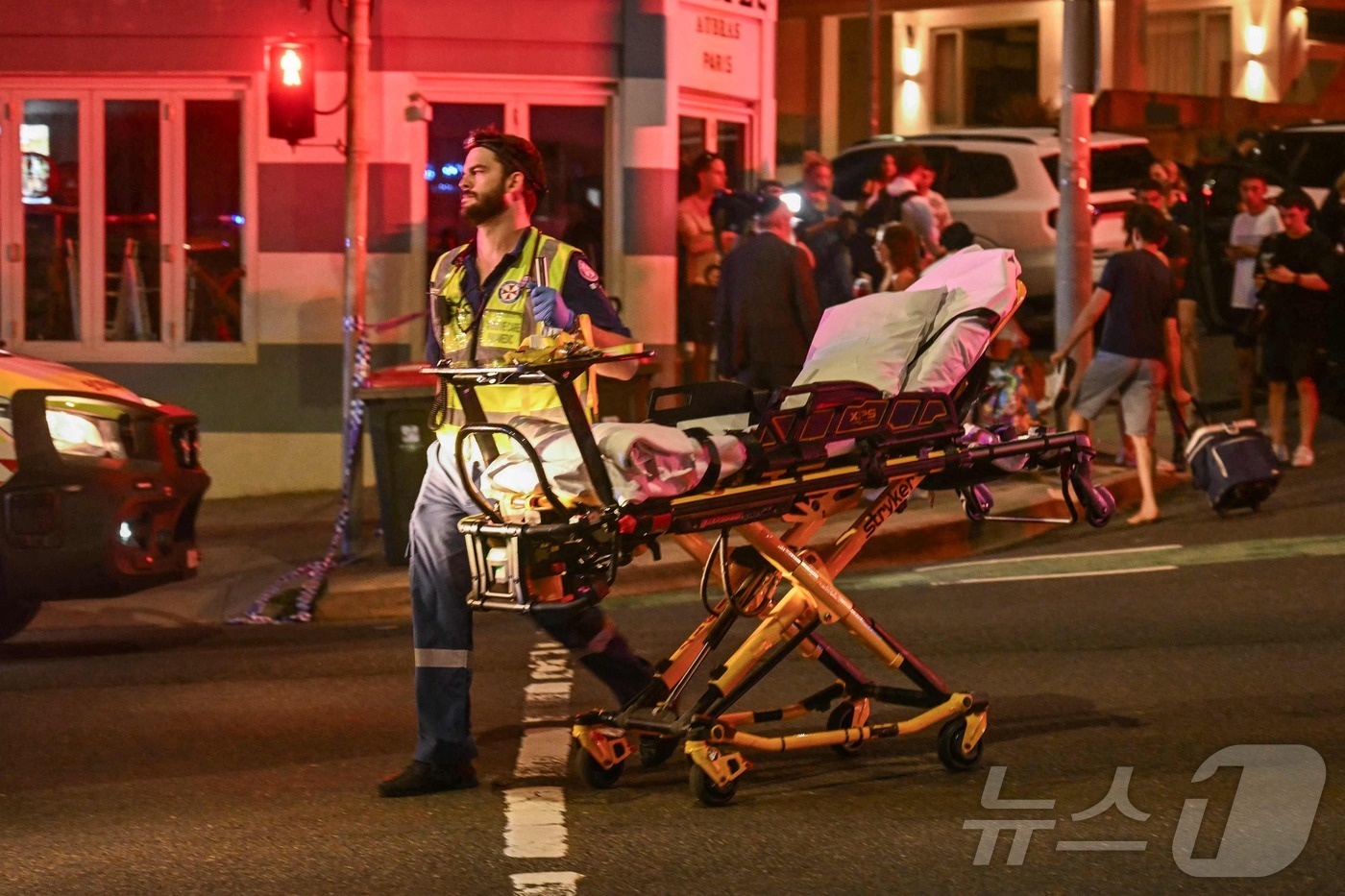 (AFP=뉴스1) = 14일(현지시간) 호주 시드니 본다이 비치에서 총격 사건이 발생한 가운데, 의료진들이 피해자들을 병원으로 후송하고 있다.ⓒ AFP=뉴스1