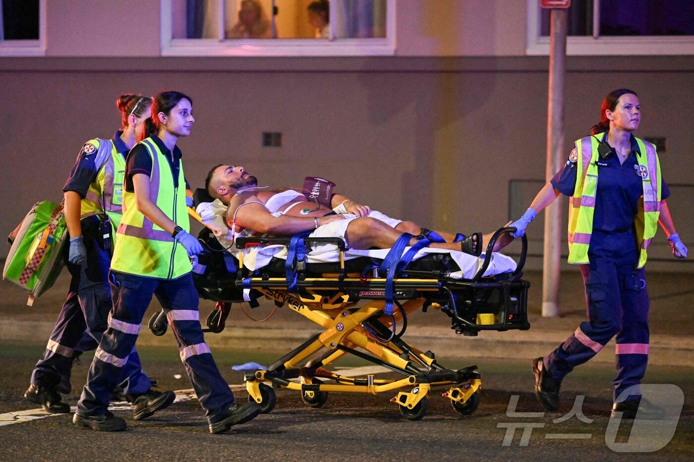 본문 이미지 - 14일(현지시간) 호주 시드니 본다이 비치에서 총격 사건이 발생한 가운데, 의료진들이 피해자들을 병원으로 후송하고 있다. ⓒ AFP=뉴스1 ⓒ News1 김성진 기자