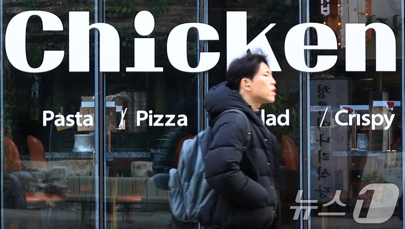 본문 이미지 - 서울 시내의 한 치킨매장 앞으로 시민이 지나가고 있다. 2025.12.15 ⓒ 뉴스1 이호윤 기자
