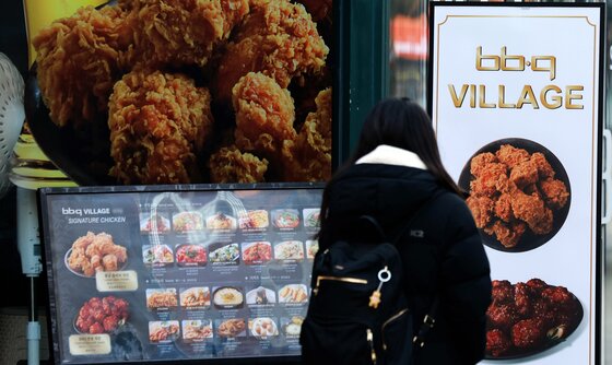 본문 이미지 - 치킨을 판매할 때 조리 전 닭고기 무게를 소비자에게 고지해야 하는 '치킨 중량표시제'가 본격적으로 시행되는 15일 서울 시내의 한 BBQ매장 앞으로 시민이 지나가고 있다. '치킨 중량표시제'는 치킨의 가격은 그대로 두고 무게를 줄이는 꼼수 인상하는 '슈링크플레이션'을 방지하기 위해 공정거래위원회, 식품의약품안전처 등 관계 부처가 합동으로 마련했으며 bhc, BBQ치킨, 교촌치킨, 처갓집양념치킨 등 상위 10개 브랜드가 매장 및 배달 주문 메뉴판에 닭고기의 조리 전 총중량을 명시해야 한다. 2025.12.15/뉴스1 ⓒ News1 이호윤 기자