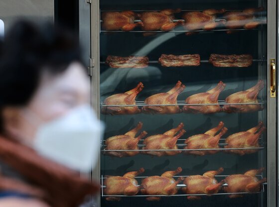 본문 이미지 - 서울 시내의 한 치킨매장 앞으로 시민이 지나가고 있다. 2025.12.15 ⓒ 뉴스1 이호윤 기자