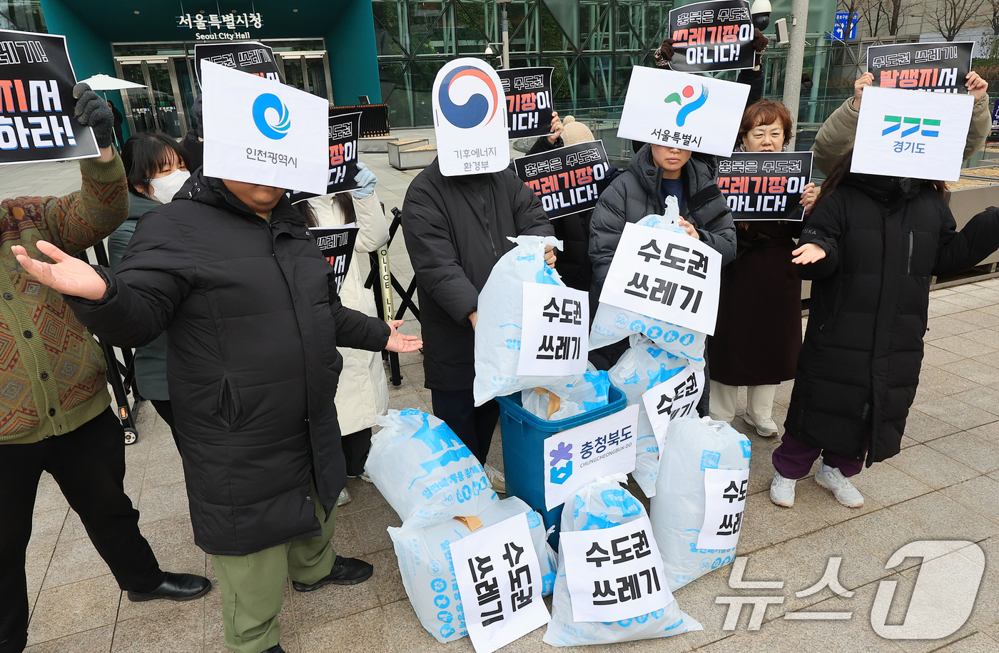(서울=뉴스1) 이호윤 기자 = 환경운동연합 회원들이 15일 서울시청 앞에서 열린 수도권 생활폐기물 처리의 환경 부정의 문제 규탄 기자회견에서 퍼포먼스를 하고 있다. 2025.12 …
