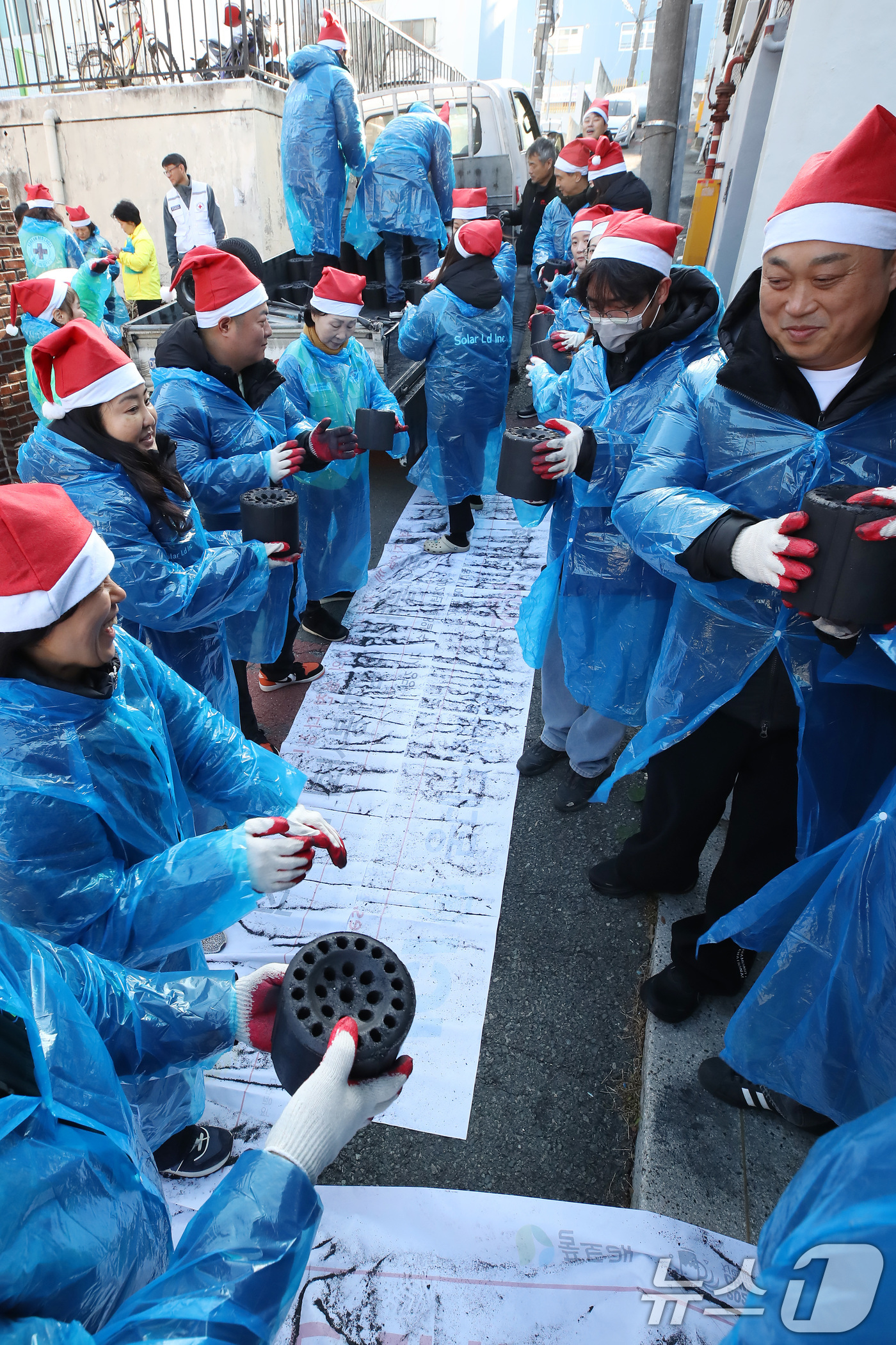 (대구=뉴스1) 공정식 기자 = 15일 오후 대구 동구 신천동 주택가에서 열린 '사랑의 연탄 나눔'에 참여한 대한적십자사 대구지사와 후원업체 봉사자들이 연탄을 주택 창고로 전달하고 …