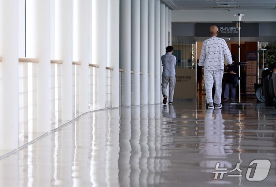 본문 이미지 - 한 환자가 서울에 있는 상급종합병원 복도를 걸어가고 있다./뉴스1 구윤성 기자