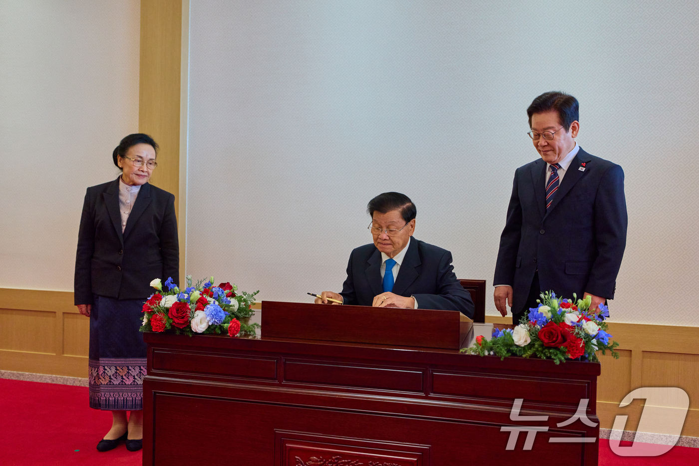 (서울=뉴스1) 허경 기자 = 한국을 공식 방한 중인 통룬 시술릿 라오스 국가주석이 15일 서울 용산 대통령실에서 방명록을 작성하고 있다. 오른쪽은 이재명 대통령. (대통령실 제공 …