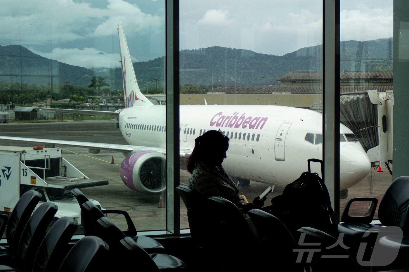 (포트 오브 스페인 AFP=뉴스1) 김경민 기자 = 트리니타드 토바고 수도 포트 오브 스페인에 위치한 피아코 국제공항에서 한 여성이 10월 휴대폰을 보고 있다. 트리니타드 토바고는 …