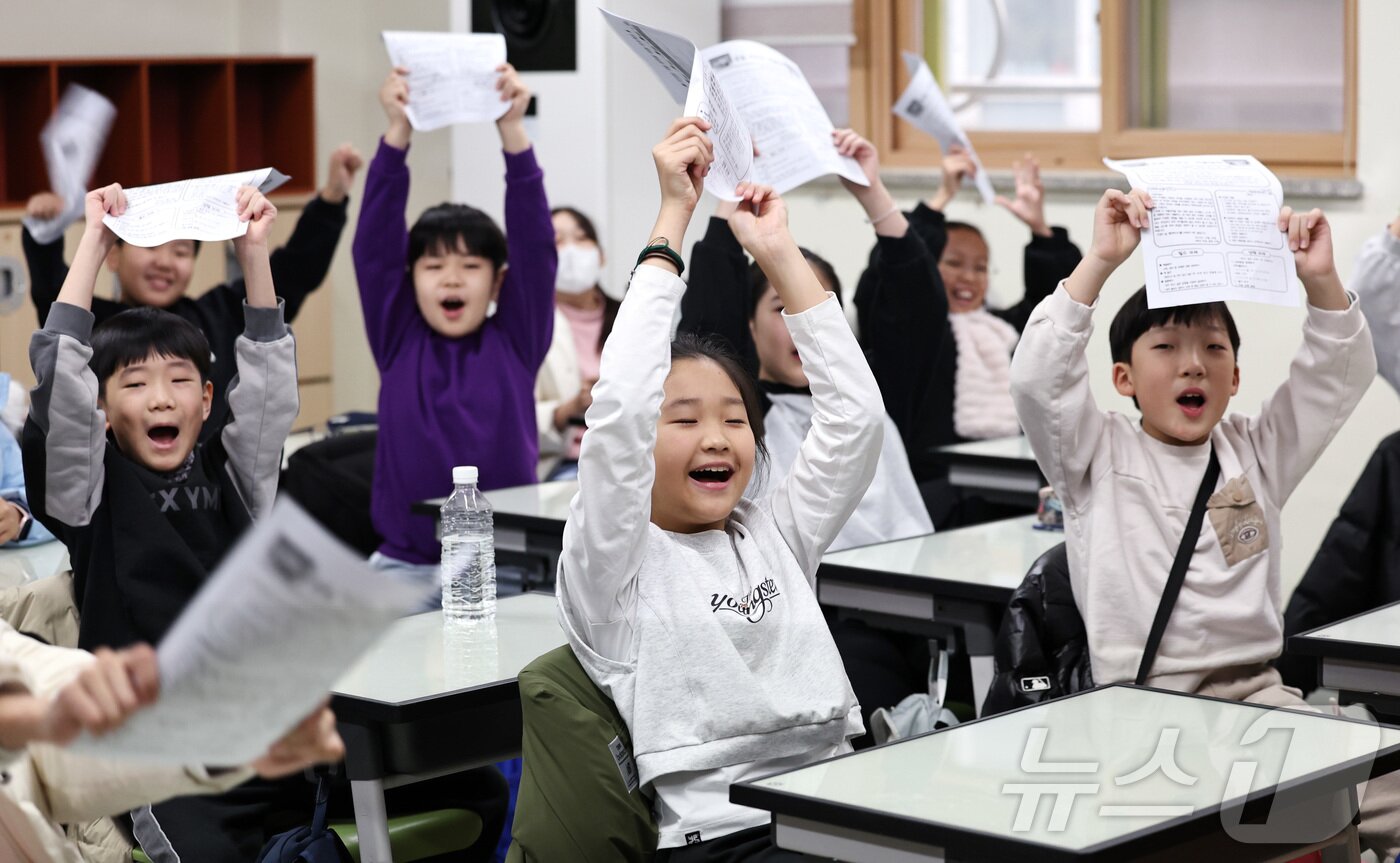 본문 이미지 - 16일 경기 수원시 영통구 잠원초등학교에서 겨울방학을 맞은 학생들이 방학계획서를 들고 환호하고 있다. ⓒ News1 구윤성 기자