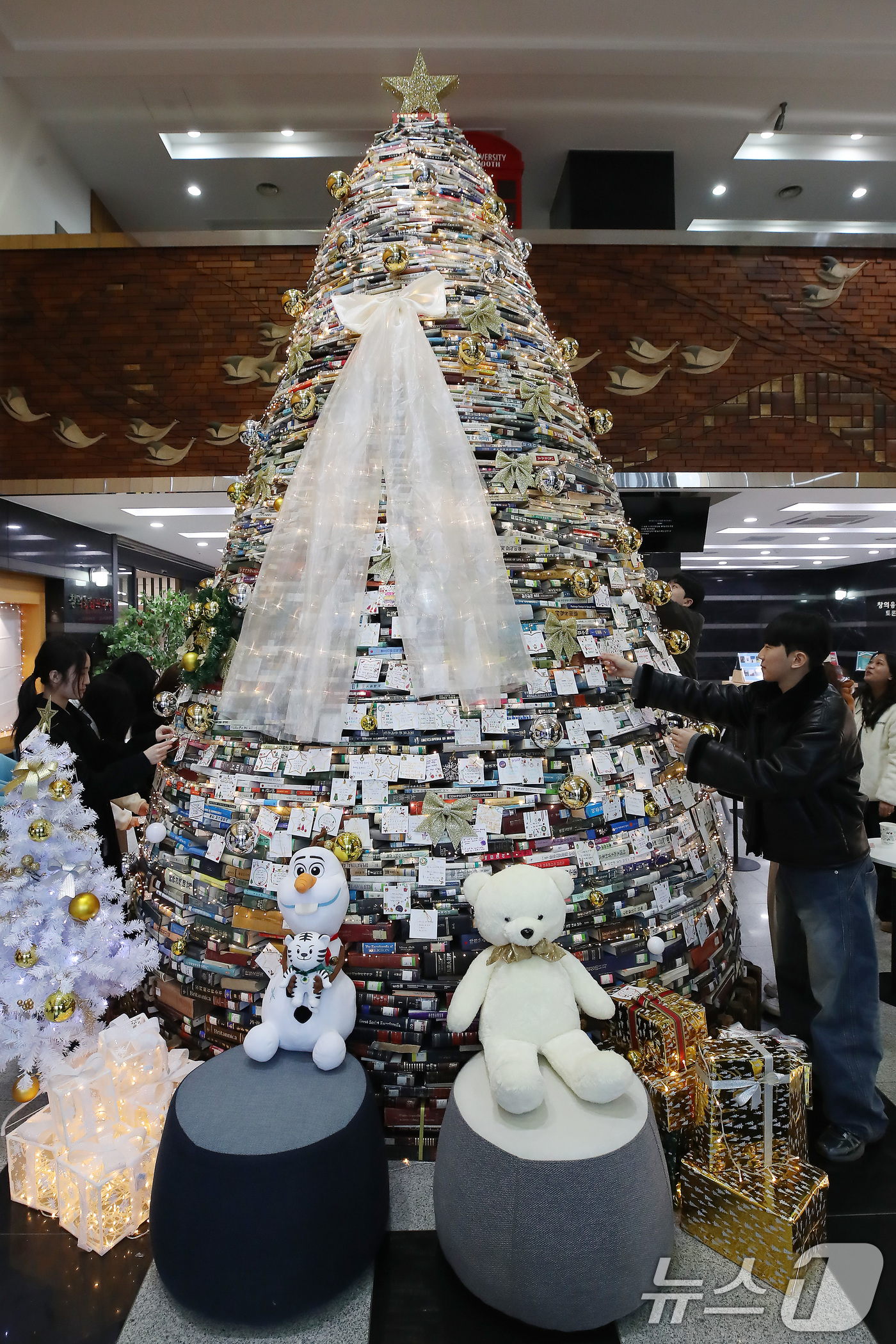 (경산=뉴스1) 공정식 기자 = 16일 오전 대구대학교 경산캠퍼스 창파도서관에서 학생들이 크리스마스를 앞두고 설치된 북(Book) 트리에 소원지를 붙이고 있다.대구대는 2008년부 …