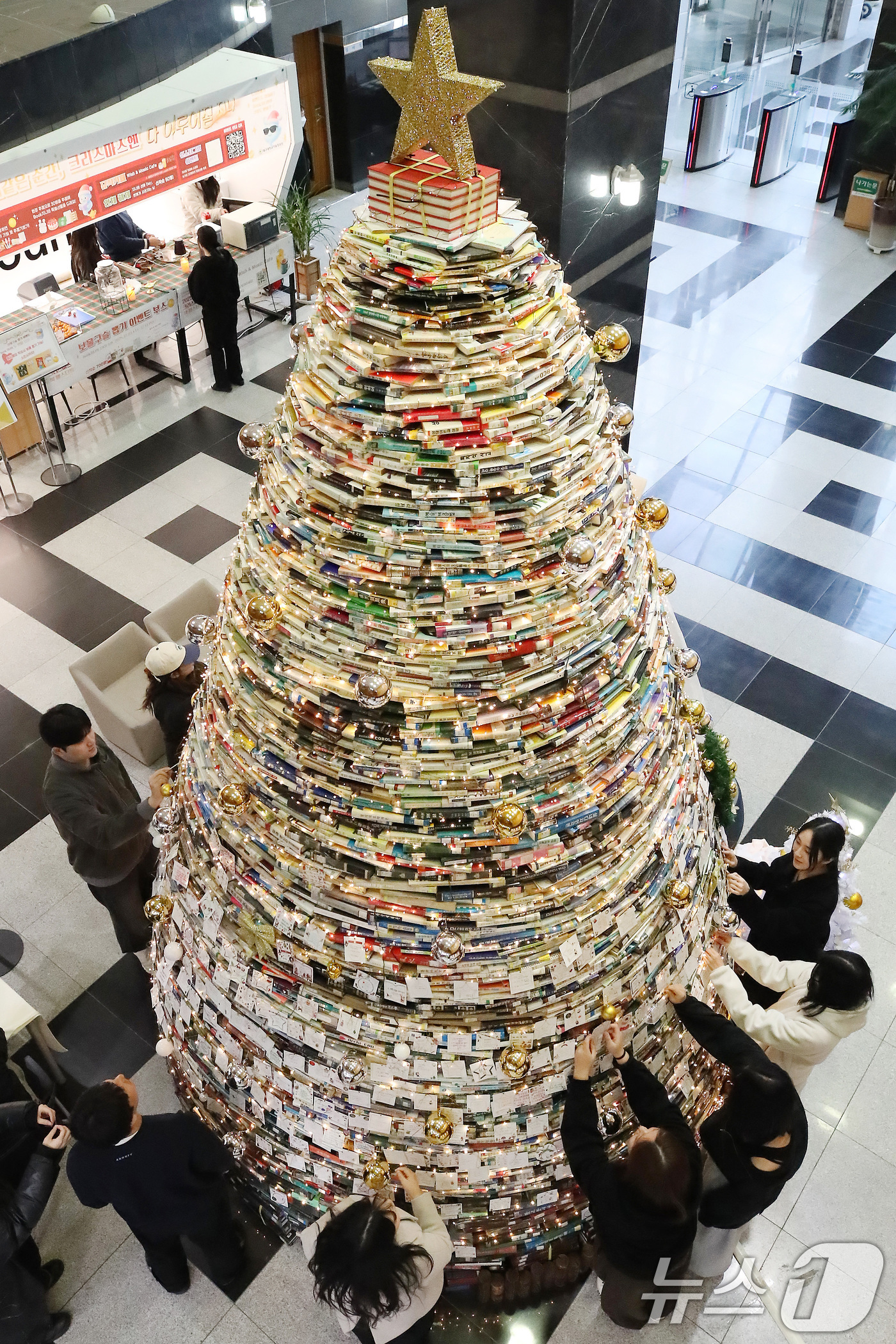(경산=뉴스1) 공정식 기자 = 16일 오전 대구대학교 경산캠퍼스 창파도서관에서 학생들이 크리스마스를 앞두고 설치된 북(Book) 트리에 소원지를 붙이고 있다.대구대는 2008년부 …