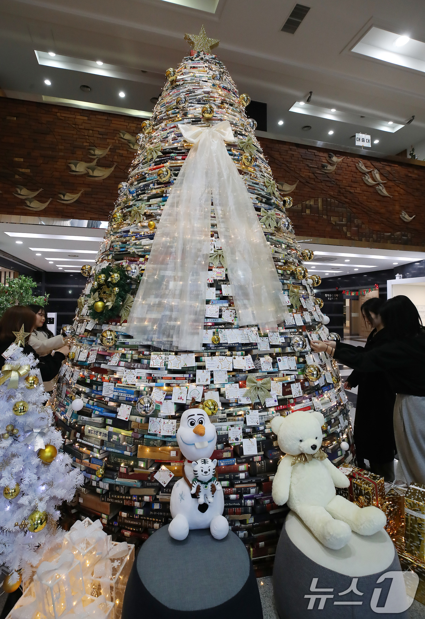 (경산=뉴스1) 공정식 기자 = 16일 오전 대구대학교 경산캠퍼스 창파도서관에서 학생들이 크리스마스를 앞두고 설치된 북(Book) 트리에 소원지를 붙이고 있다.대구대는 2008년부 …