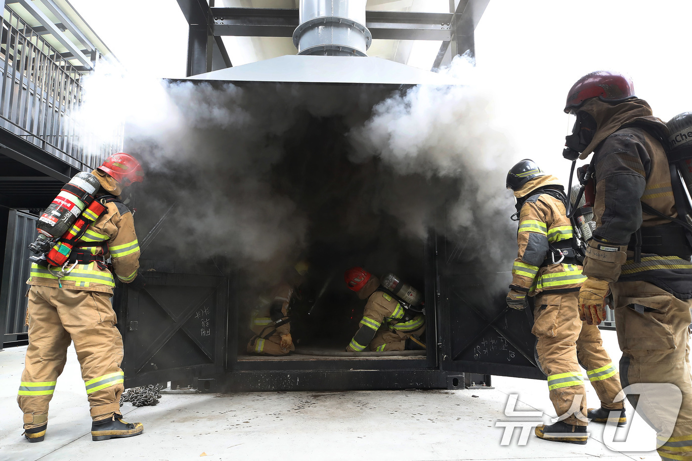 (대구=뉴스1) 공정식 기자 = 16일 오후 대구 동구 대구소방교육안전센터에서 열린 '실화재 종합훈련 역량강화 특별교육'에 참여한 소방관들이 컨테이너 모형주택 내부에서 불과 연기가 …