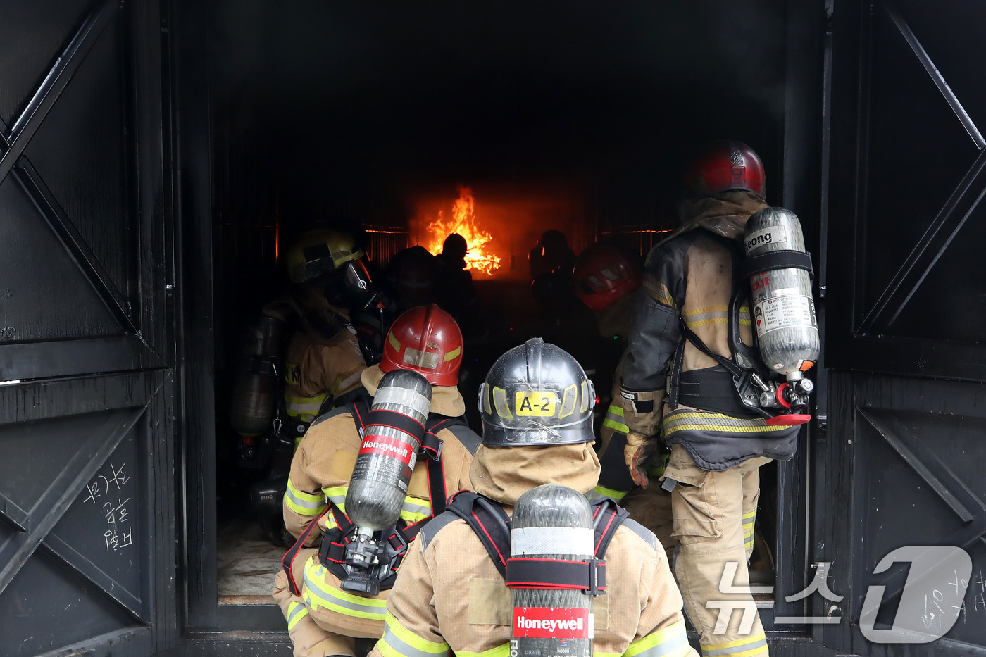 (대구=뉴스1) 공정식 기자 = 16일 오후 대구 동구 대구소방교육안전센터에서 열린 '실화재 종합훈련 역량강화 특별교육'에 참여한 소방관들이 컨테이너 모형주택 내부에서 불과 연기가 …