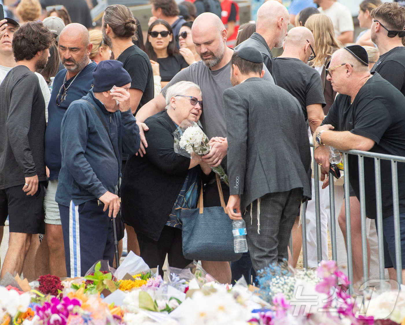 (시드니 로이터=뉴스1) 권영미 기자 = 16일 호주 시드니 본다이 비치 대규모 총격 사건으로 숨진 10세 소녀 마틸다의 조부모가 희생자를 추모하는 꽃 헌화 장소에서 사람들의 위로 …