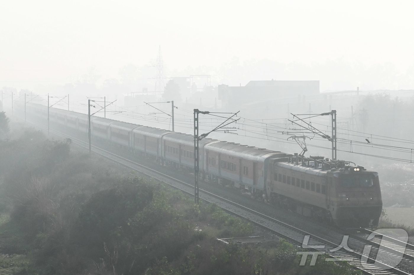 (암리차르 AFP=뉴스1) 권영미 기자 = 16일 짙은 스모그가 낀 인도 암리차르 외곽에서 한 열차가 철로를 따라 달리고 있다.2025.12.16.ⓒ AFP=뉴스1