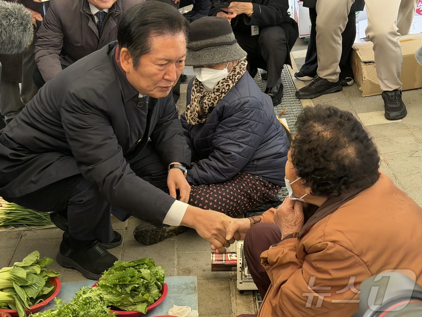 (춘천=뉴스1) 한귀섭 기자 = 정청래 더불어민주당 대표와 육동한 춘천시장 등이 17일 강원 춘천 온의동 풍물시장에서 상인과 인사를 나누고 있다. 2025.12.17/뉴스1