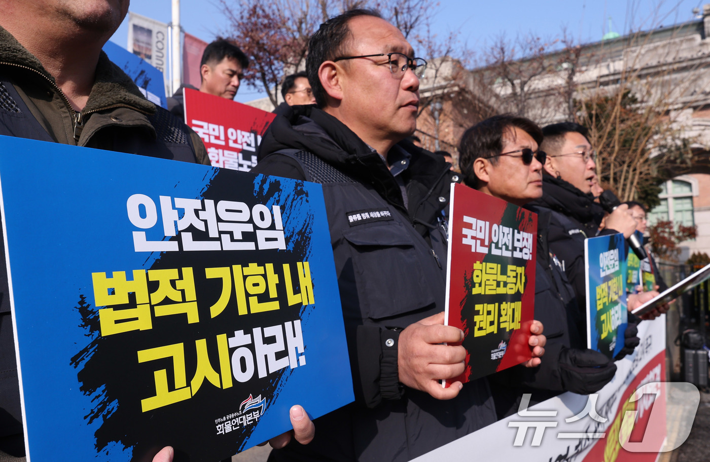 (서울=뉴스1) 박지혜 기자 = 민주노총 공공운수노조 화물연대본부 조합원들이 17일 서울 중구 서울역 광장에서 열린 전국 동시다발 농성투쟁 돌입 기자회견에서 의도적으로 안전운임 교 …