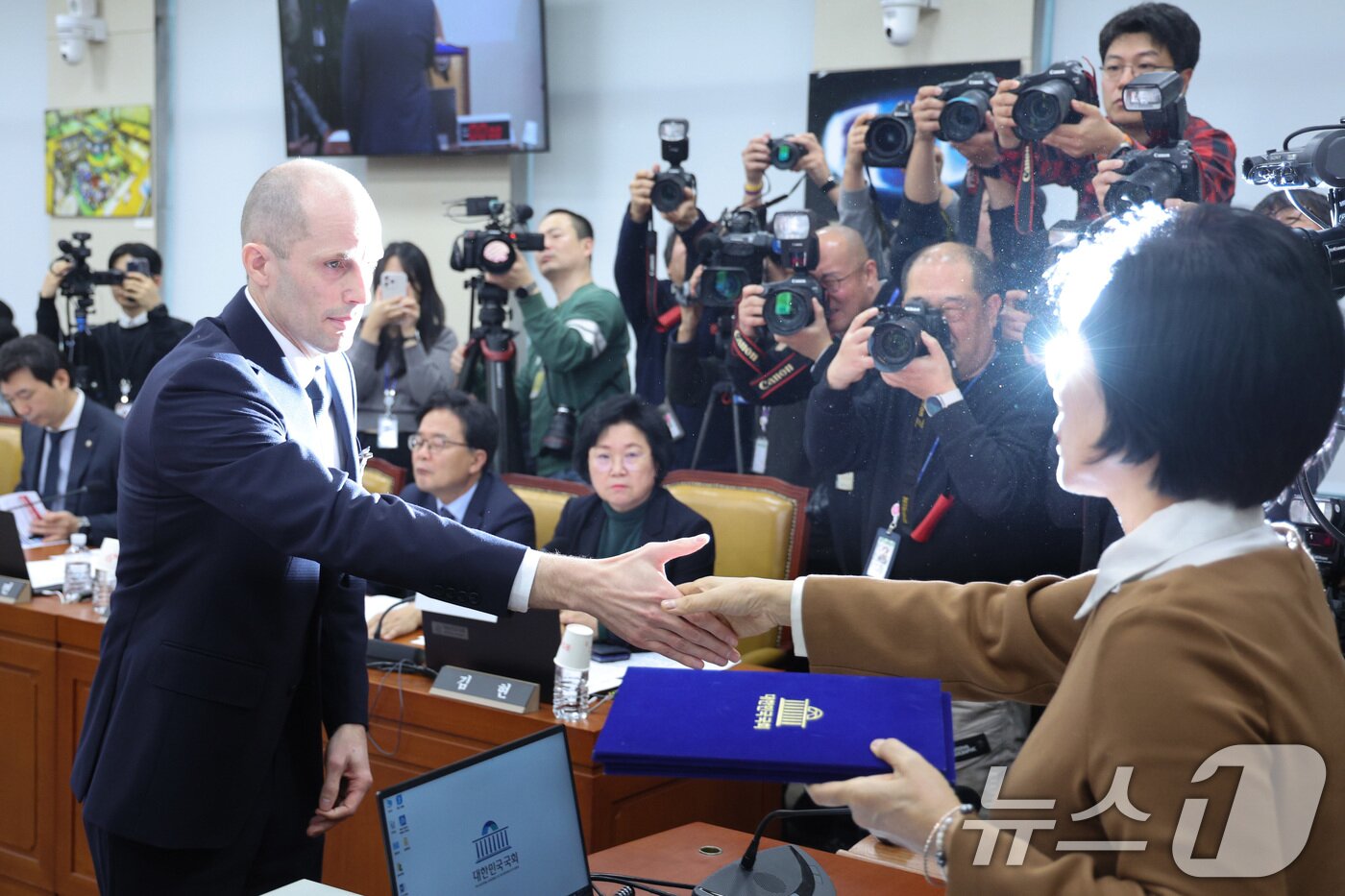 본문 이미지 - 해롤드 로저스 쿠팡 임시 대표가 17일 서울 여의도 국회 과학기술정보방송통신위원회에서 열린 쿠팡 침해사고 관련 청문회에서 증인 선서문을 최민희 위원장에게 제출하고 있다. 2025.12.17/뉴스1 ⓒ News1 신웅수 기자