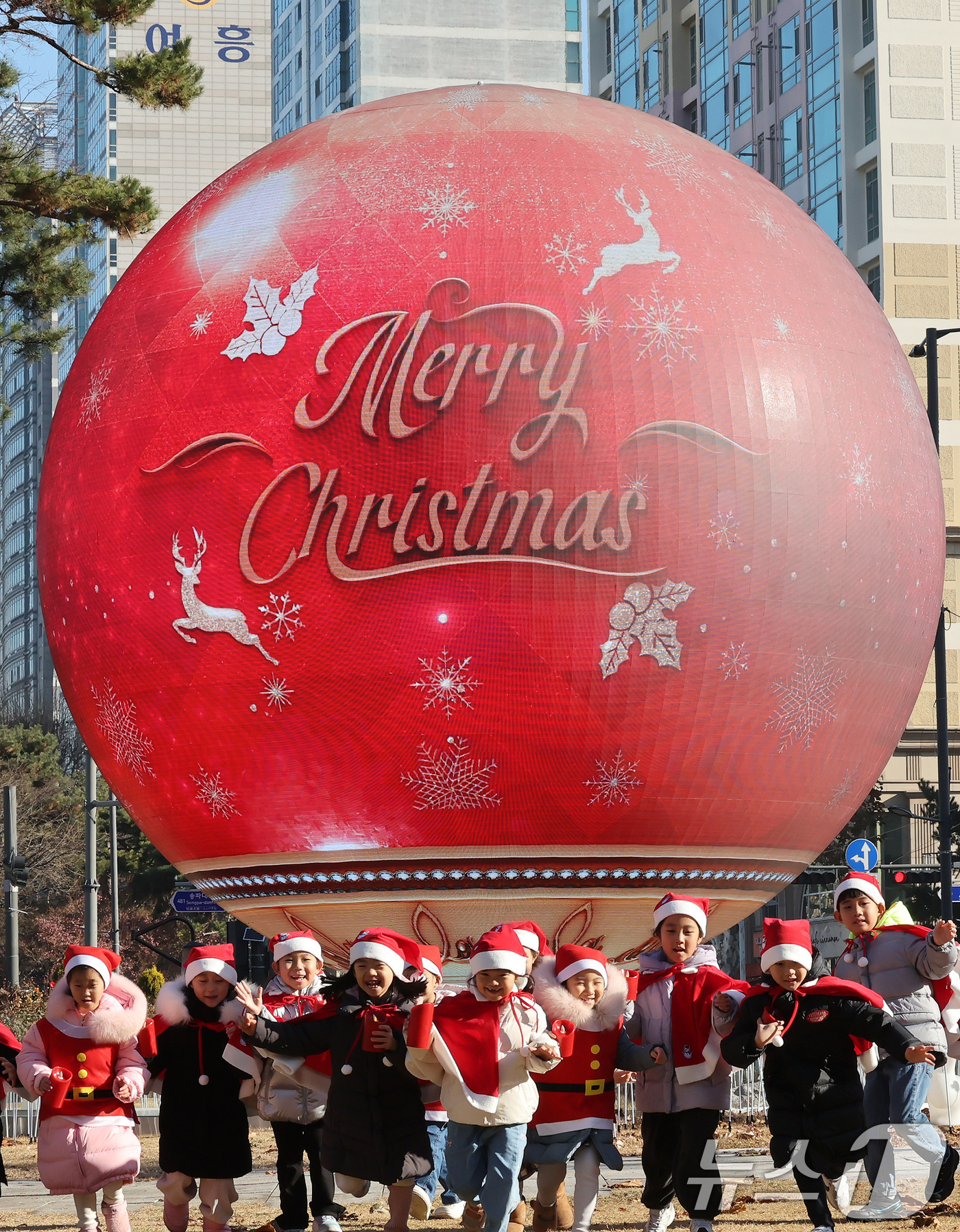 (서울=뉴스1) 장수영 기자 = 산타 복장을 차려입은 송파구청 어린이집 아이들이 18일 오전 서울 송파구 석촌호수 더 스피어에서 놀이를 하고 있다.송파구는 연말연시를 맞아 더 스피 …