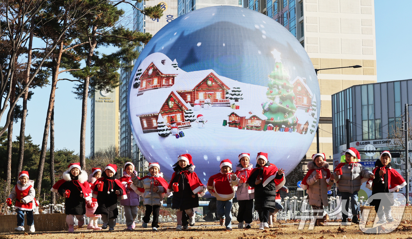 (서울=뉴스1) 장수영 기자 = 산타 복장을 차려입은 송파구청 어린이집 아이들이 18일 오전 서울 송파구 석촌호수 더 스피어에서 놀이를 하고 있다.송파구는 연말연시를 맞아 더 스피 …