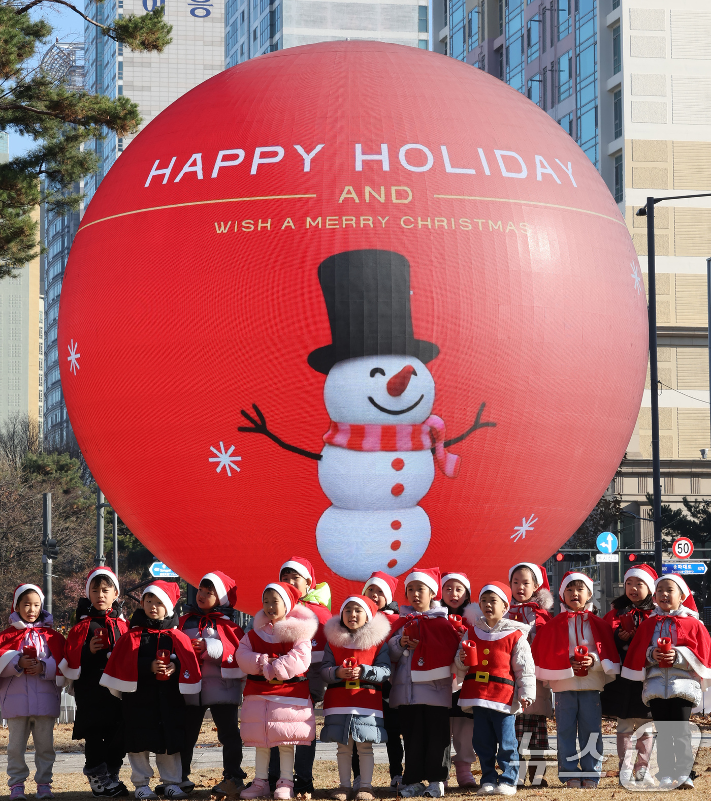 (서울=뉴스1) 장수영 기자 = 18일 오전 서울 송파구 석촌호수 더 스피어에서 산타 복장을 차려입은 송파구청 어린이집 아이들이 크리스마스 캐럴을 부르고 있다.송파구는 연말연시를 …