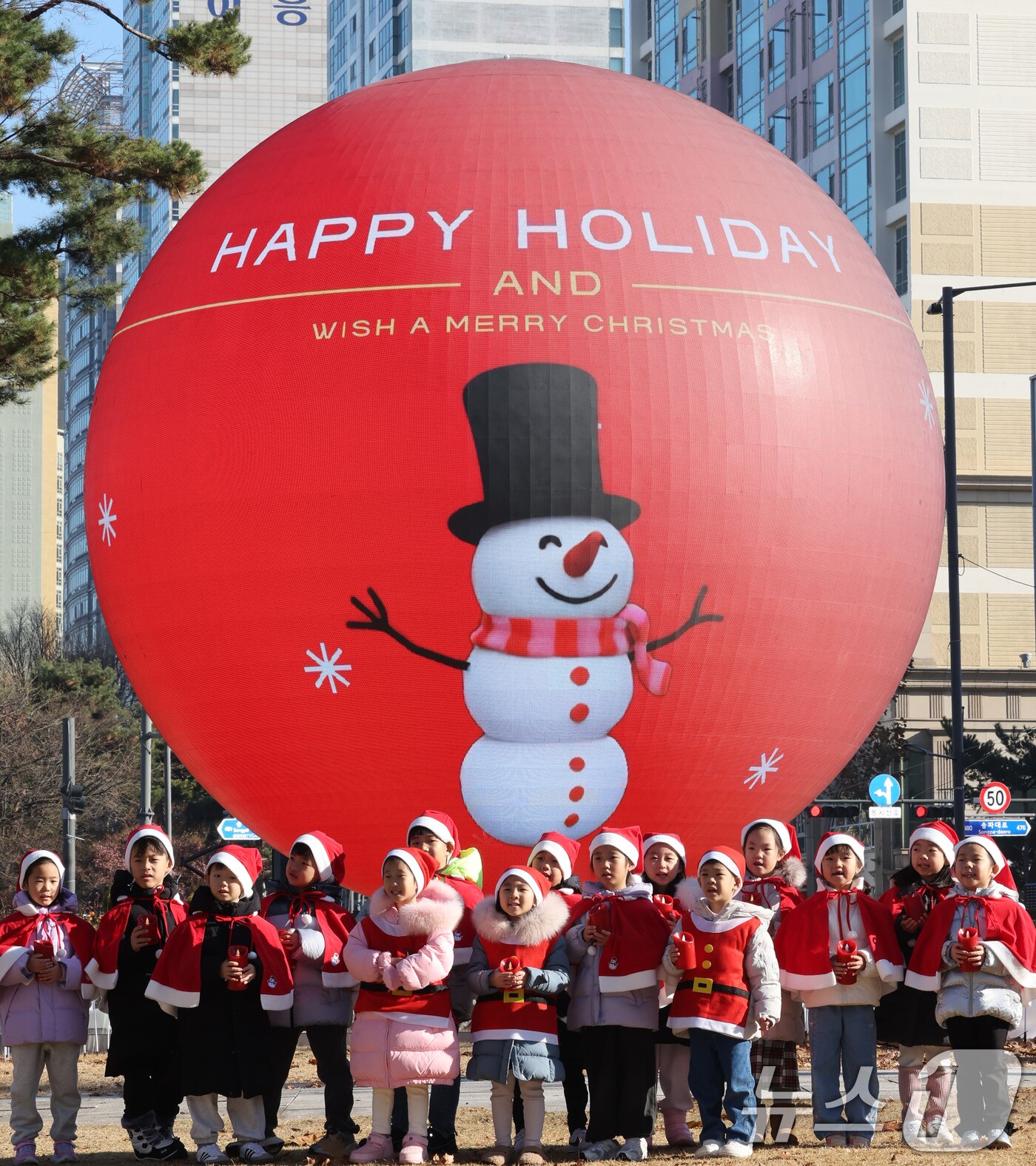 본문 이미지 - 18일 오전 서울 송파구 석촌호수 더 스피어에서 산타 복장을 차려입은 송파구청 어린이집 아이들이 크리스마스 캐럴을 부르고 있다. 2025.12.18/뉴스1 ⓒ News1 장수영 기자