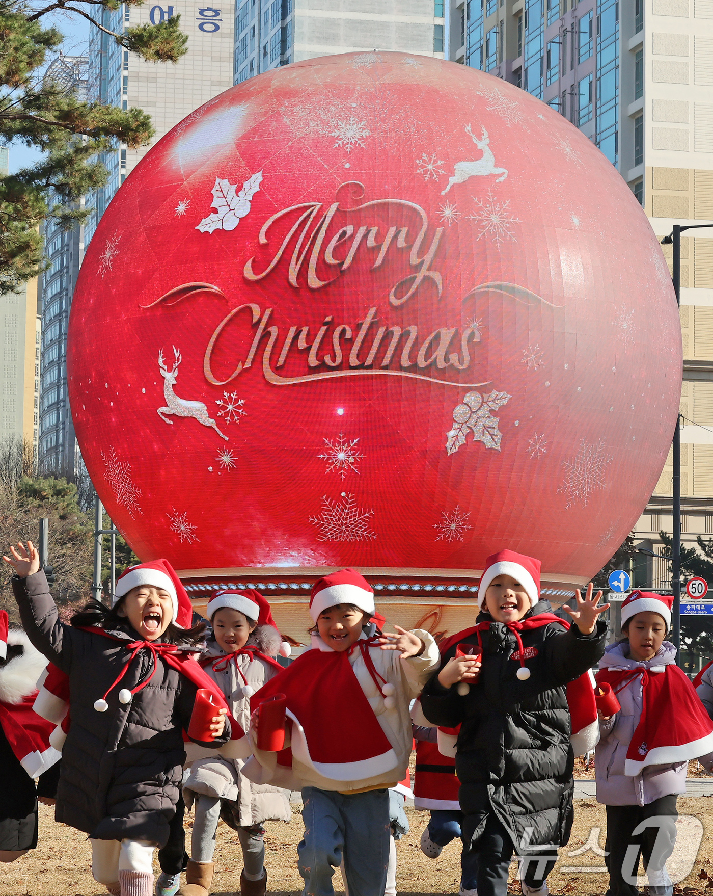 (서울=뉴스1) 장수영 기자 = 산타 복장을 차려입은 송파구청 어린이집 아이들이 18일 오전 서울 송파구 석촌호수 더 스피어에서 놀이를 하고 있다.송파구는 연말연시를 맞아 더 스피 …
