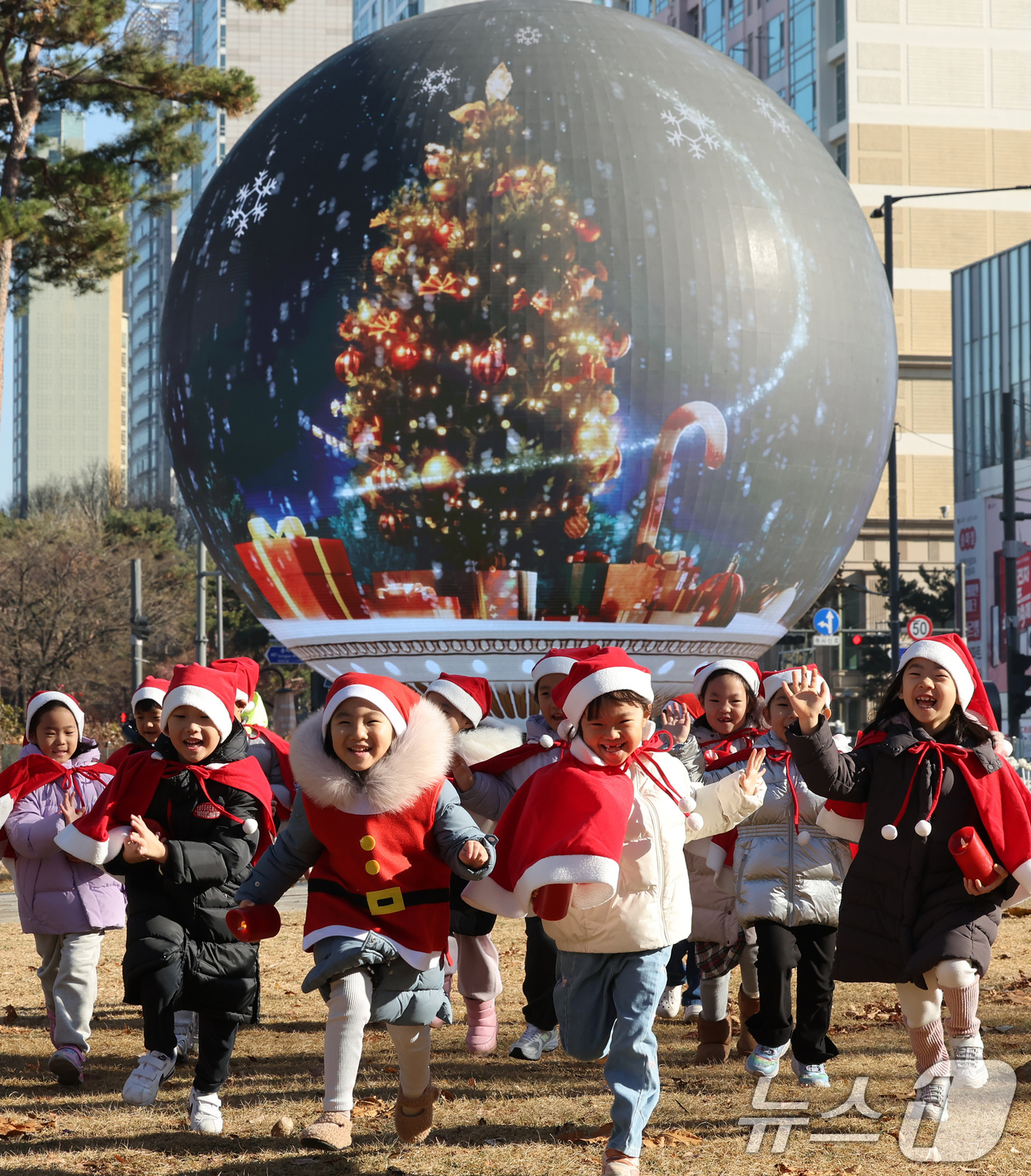 (서울=뉴스1) 장수영 기자 = 산타 복장을 차려입은 송파구청 어린이집 아이들이 18일 오전 서울 송파구 석촌호수 더 스피어에서 놀이를 하고 있다.송파구는 연말연시를 맞아 더 스피 …